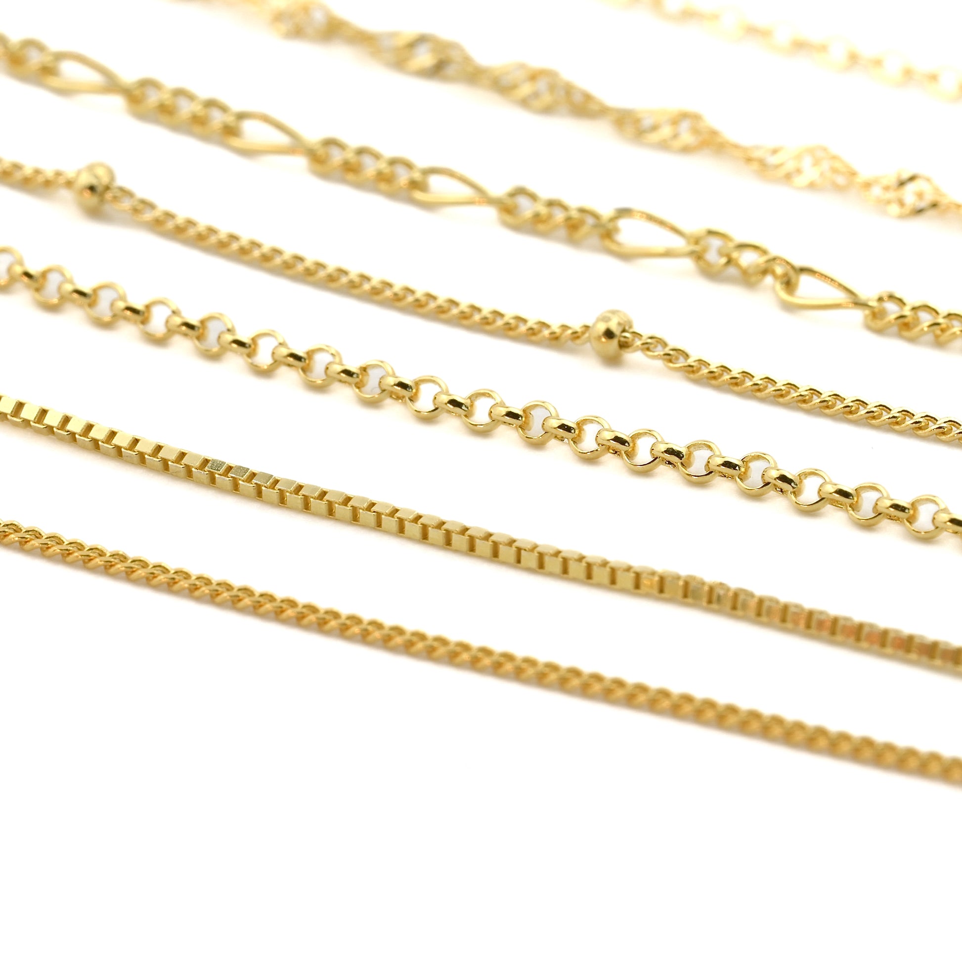 Collection of gold chains on a white background