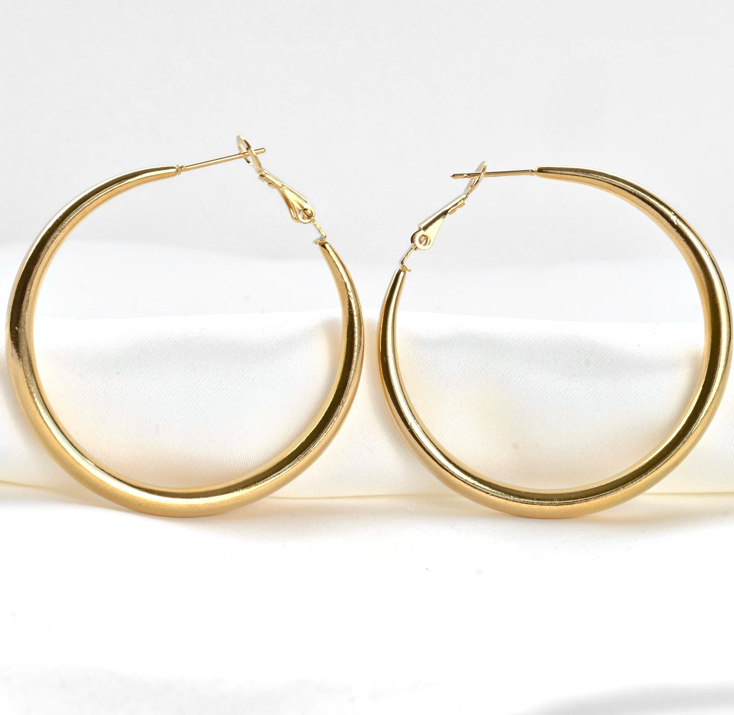 Close-up view of large hoop earrings on a white background