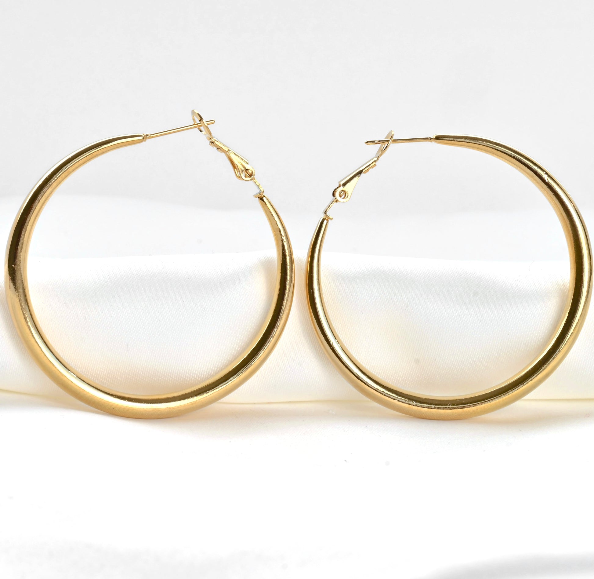 Close-up view of large hoop earrings on a white background