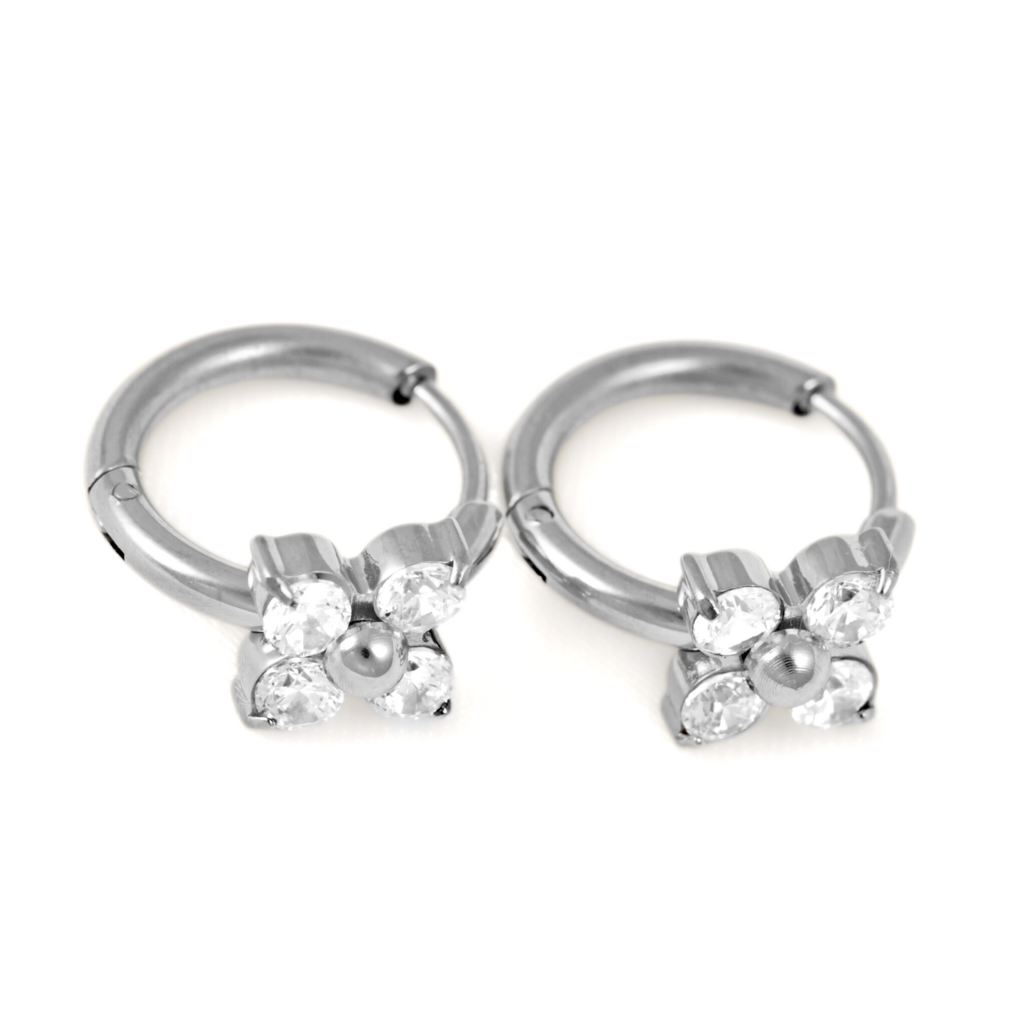 A pair of silver-toned hoop earrings with a small flower charm made of clear rhinestones and a central silver bead, shown on a plain white background.