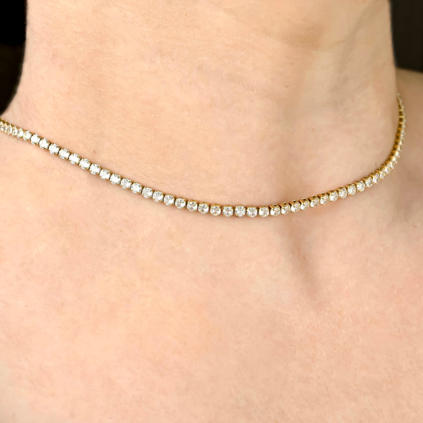 Gold tennis necklace with 3mm diamonds on a person's neck