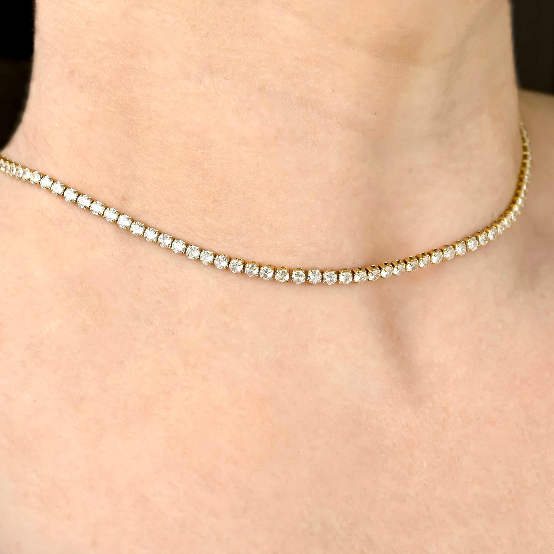 Gold tennis necklace with 3mm diamonds on a person's neck