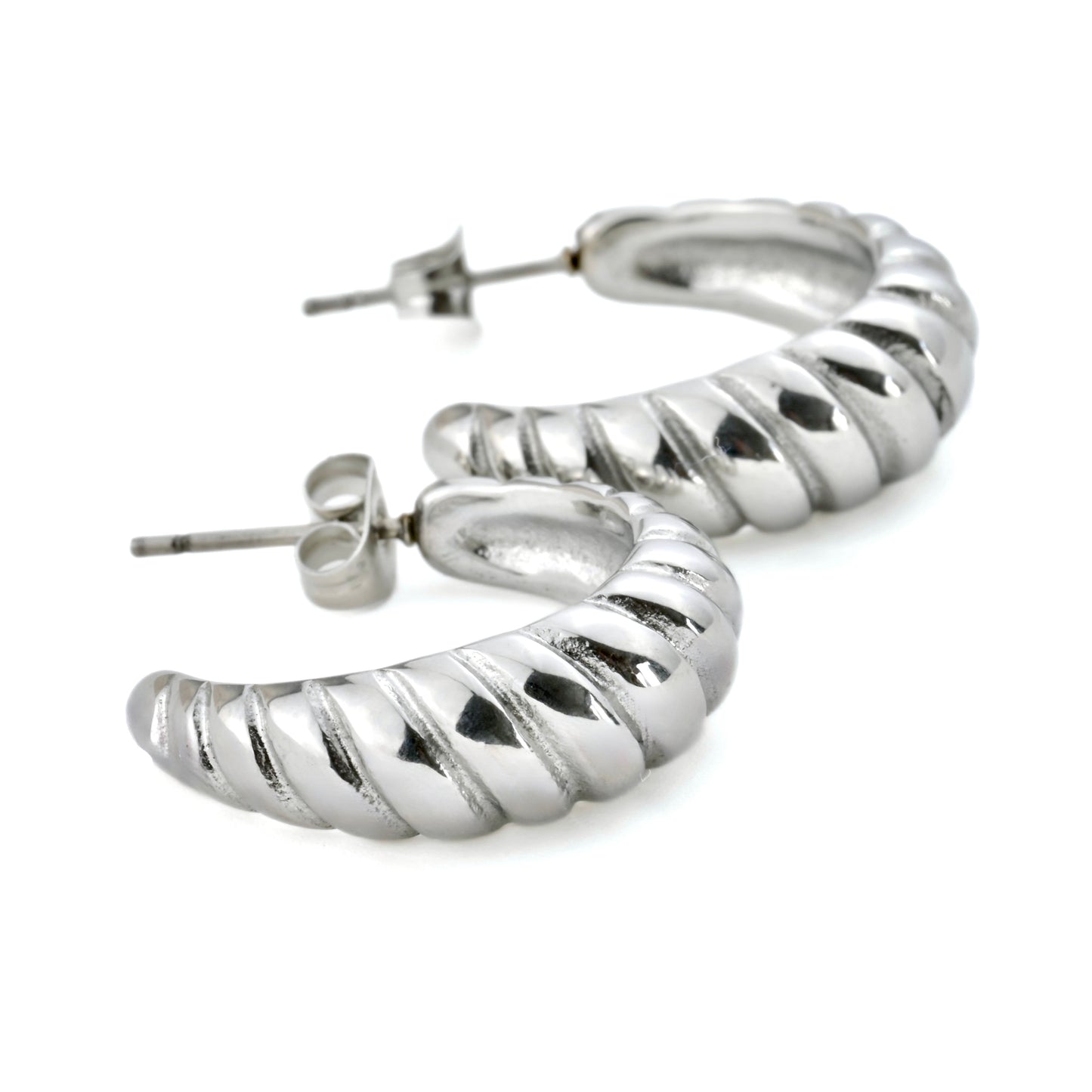 Close up view of silver C hoops on a white background