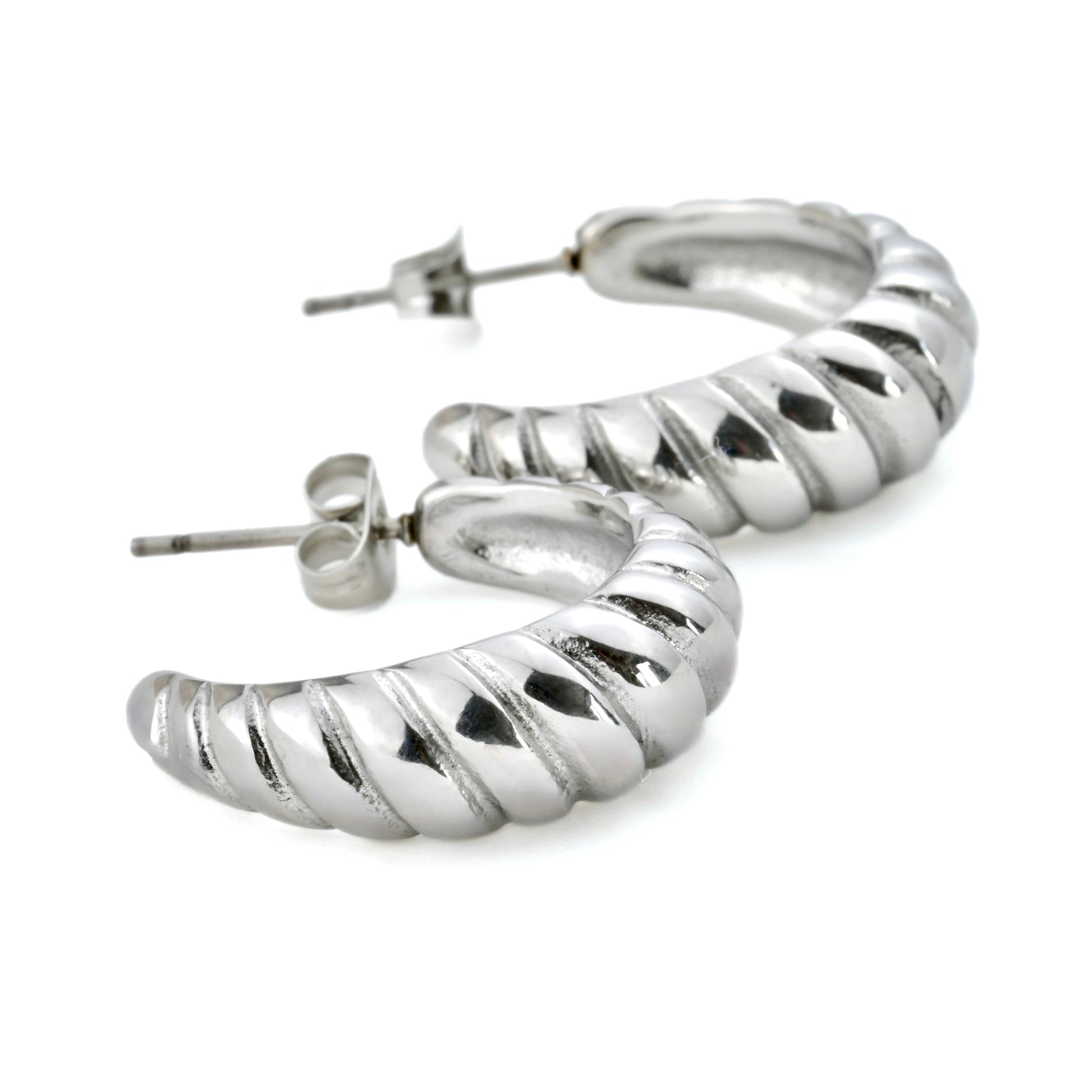 Close up view of silver C hoops on a white background