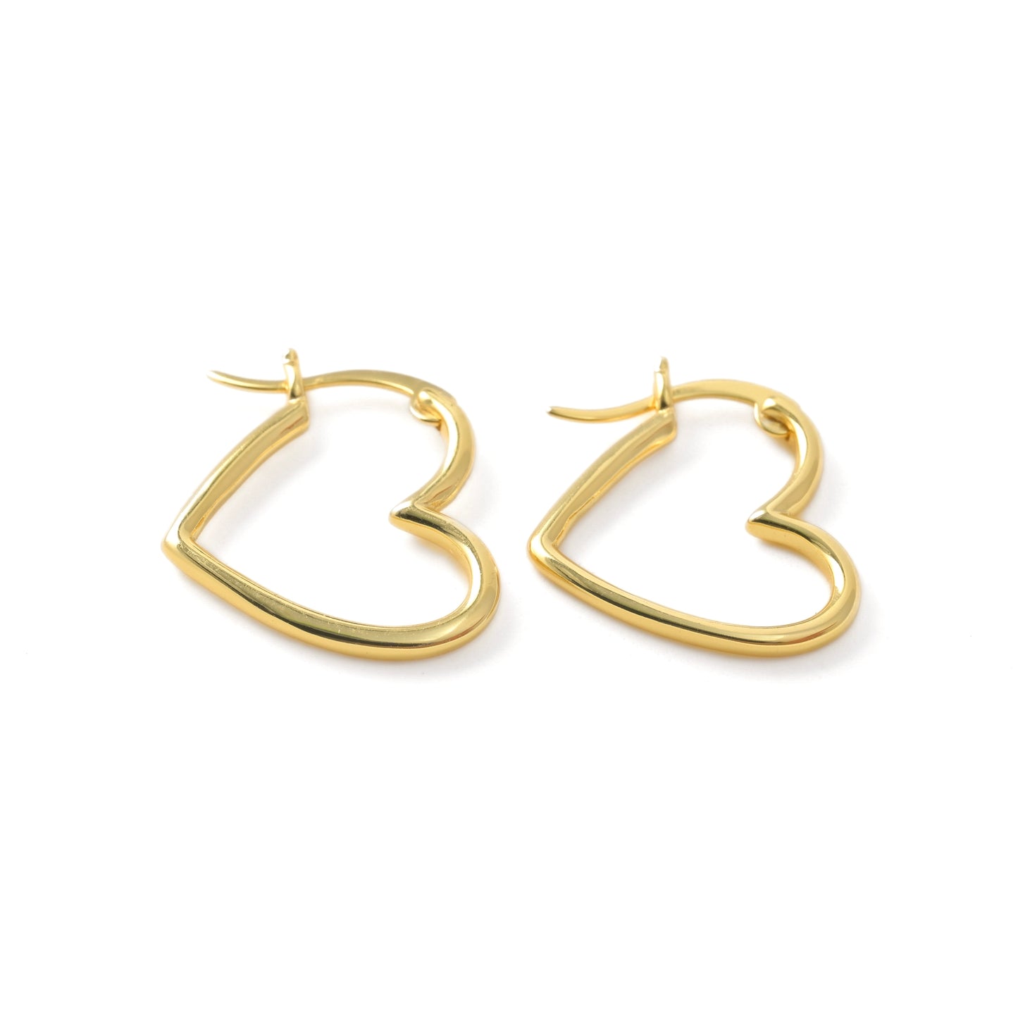 Thin gold heart hoops in sterling silver on a white background