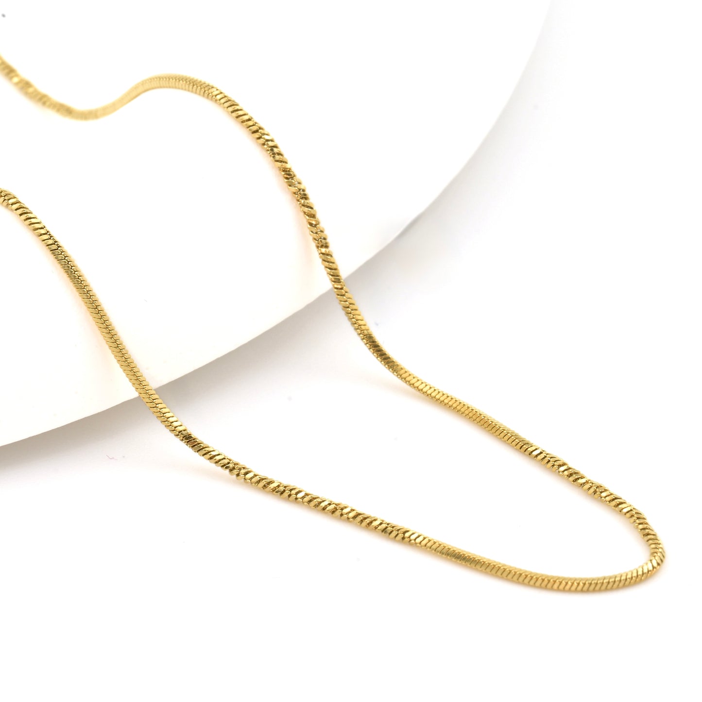Gold layering chain necklace on a white background