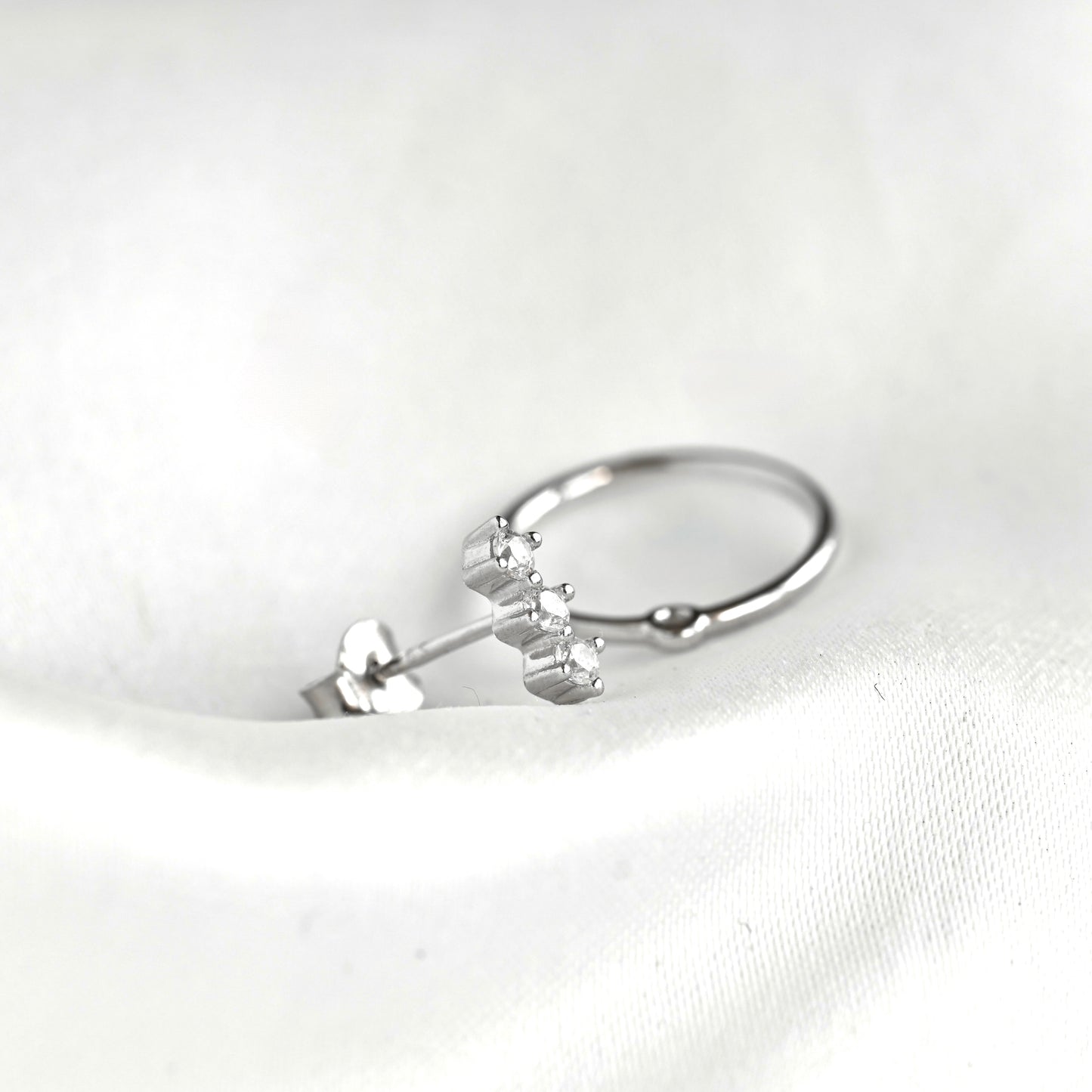 Silver diamond bar stud with butterfly back and a circle which can be attached to the bar stud displayed on white background