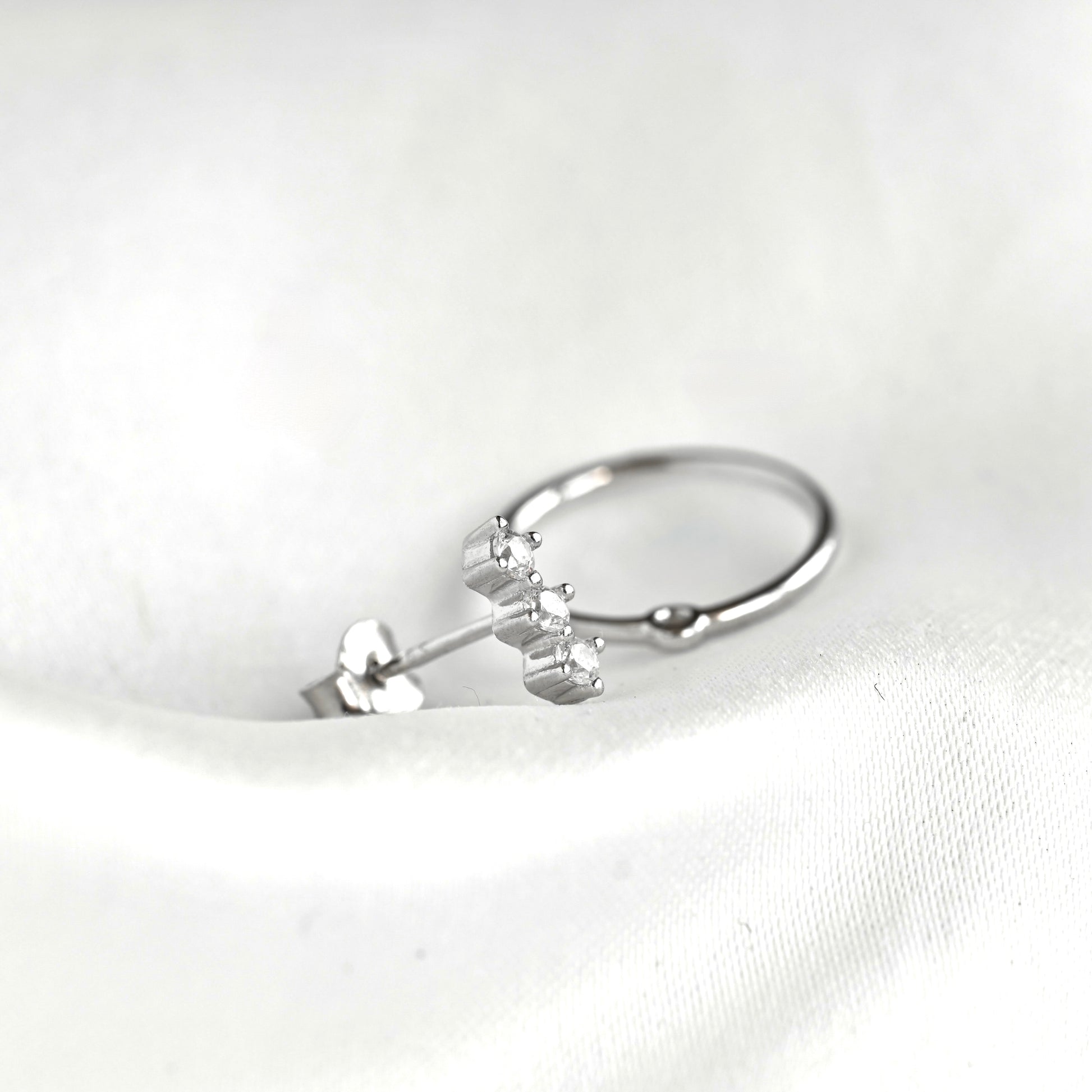 Silver diamond bar stud with butterfly back and a circle which can be attached to the bar stud displayed on white background