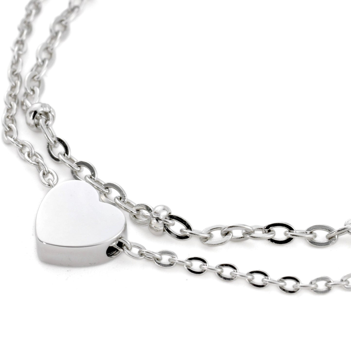 Close up view of silver anklet with a heart-shaped pendant on a white background 