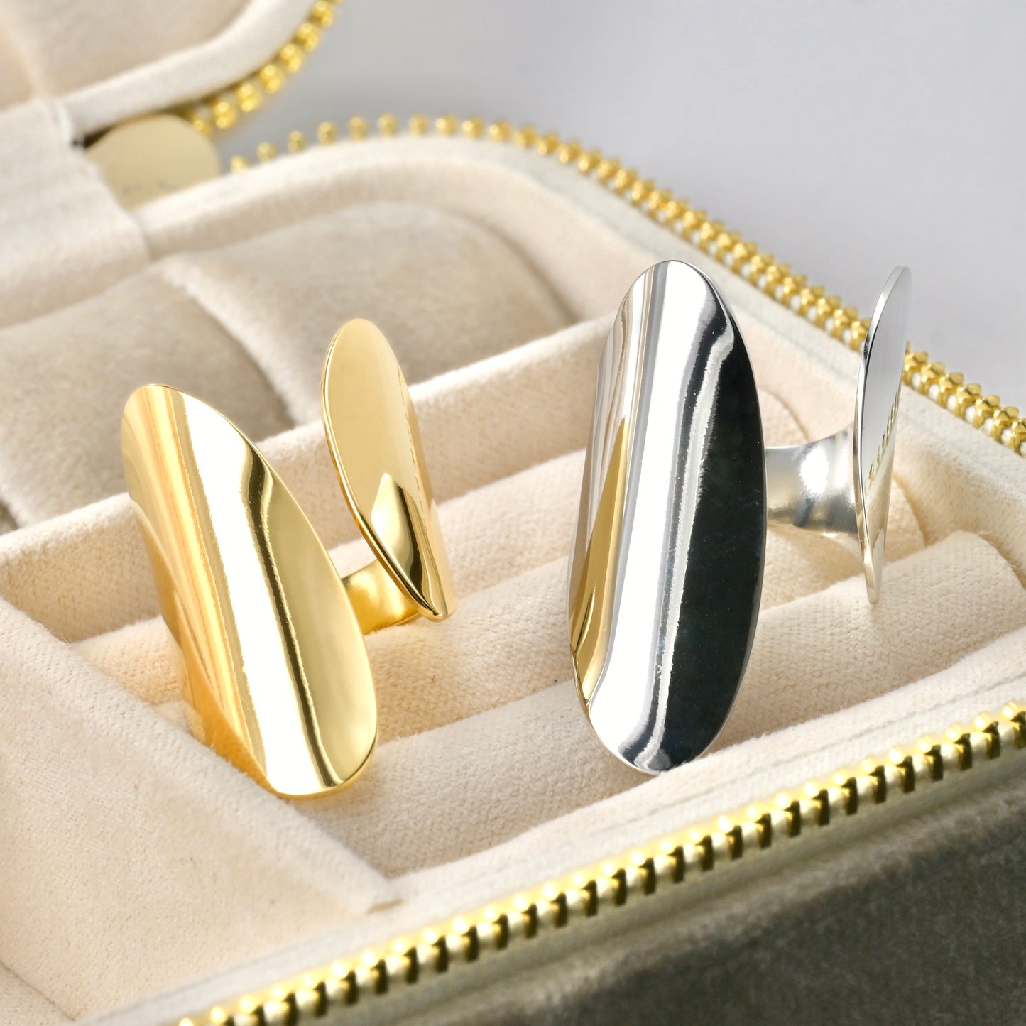 Gold and silver adjustable open rings on a jewelry case.