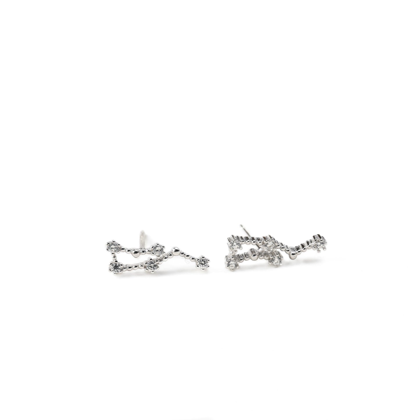 a pair of silver zodiac earrings with cz on a white background