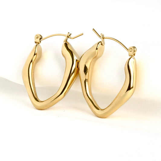Pair of irregular shape gold hoop earrings on a white background