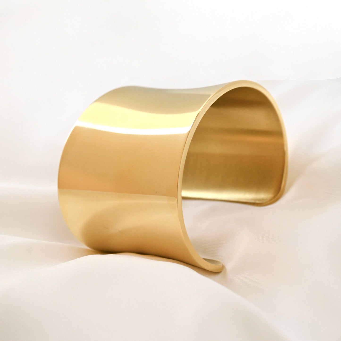 Gold cuff bracelet on a white background