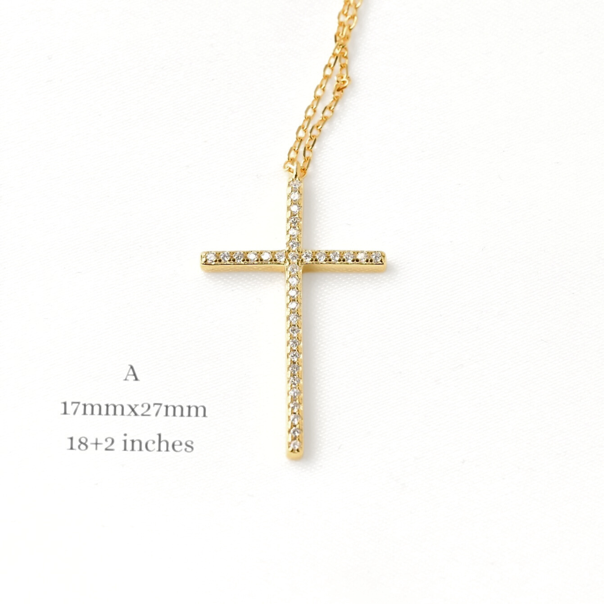 Large gold cross necklace on a white background with dimensions displayed.