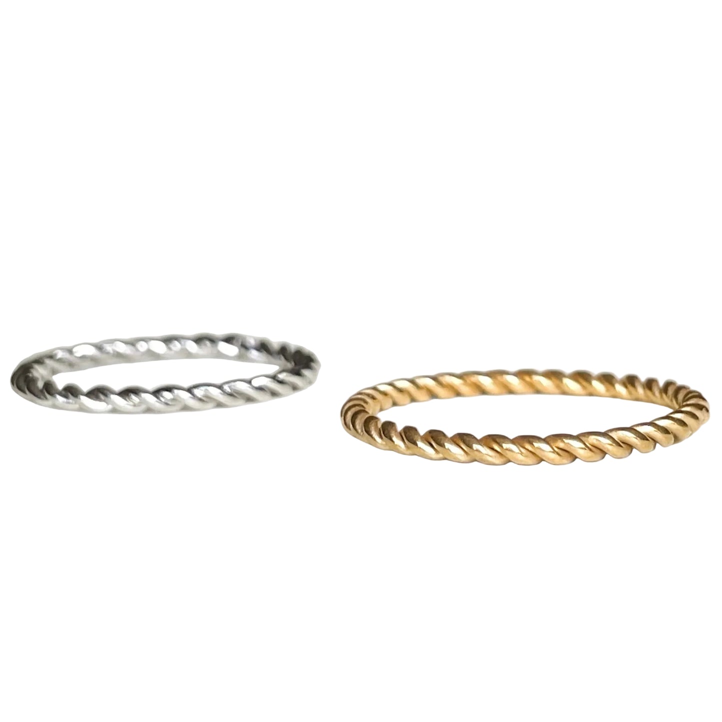 Two twisted metal rings, one silver and one gold, on a white background.