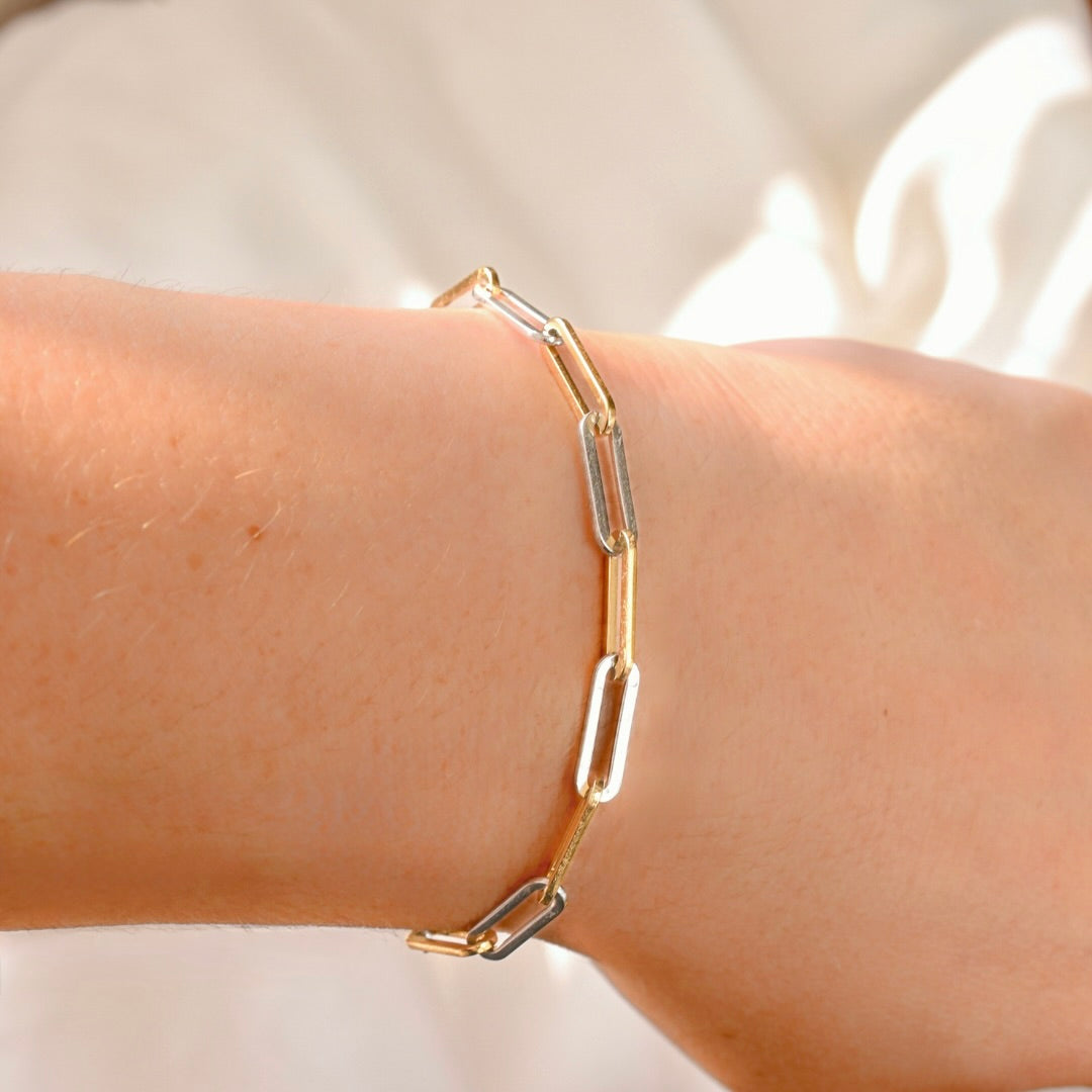 two-tone chain bracelet on a wrist with a light background
