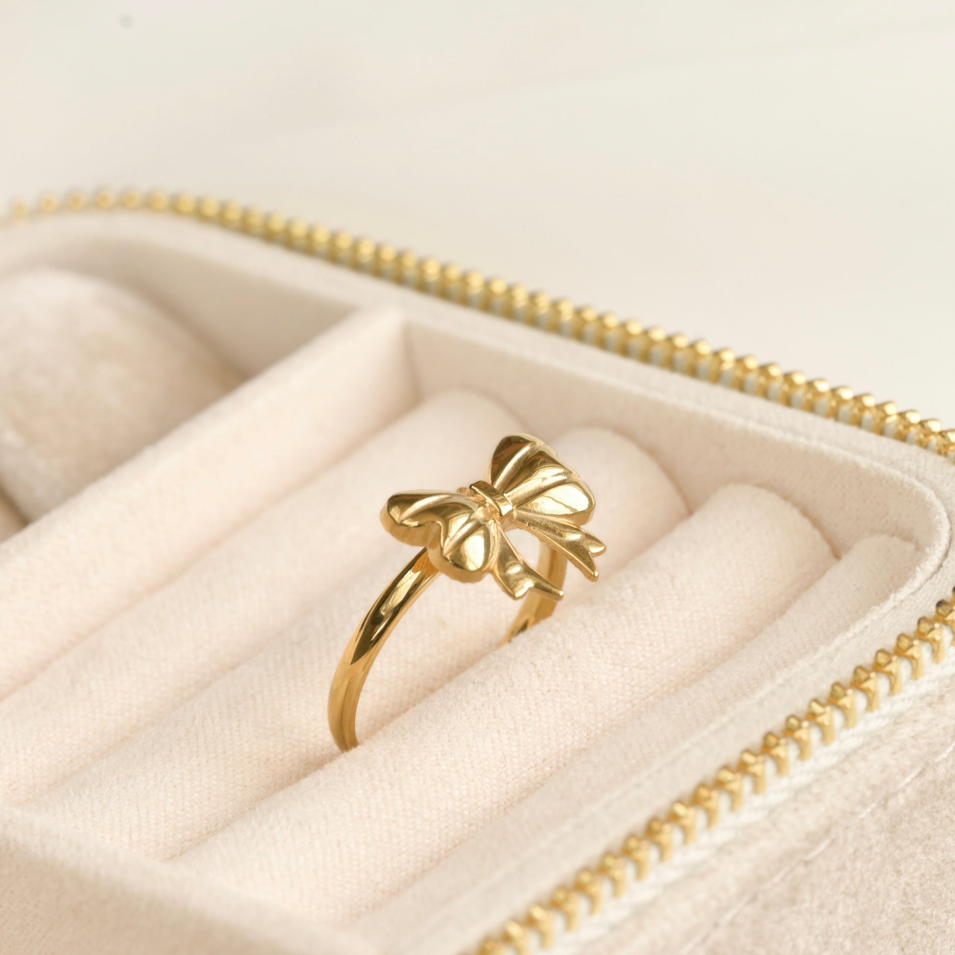 Gold bow-shaped ring in a jewelry box