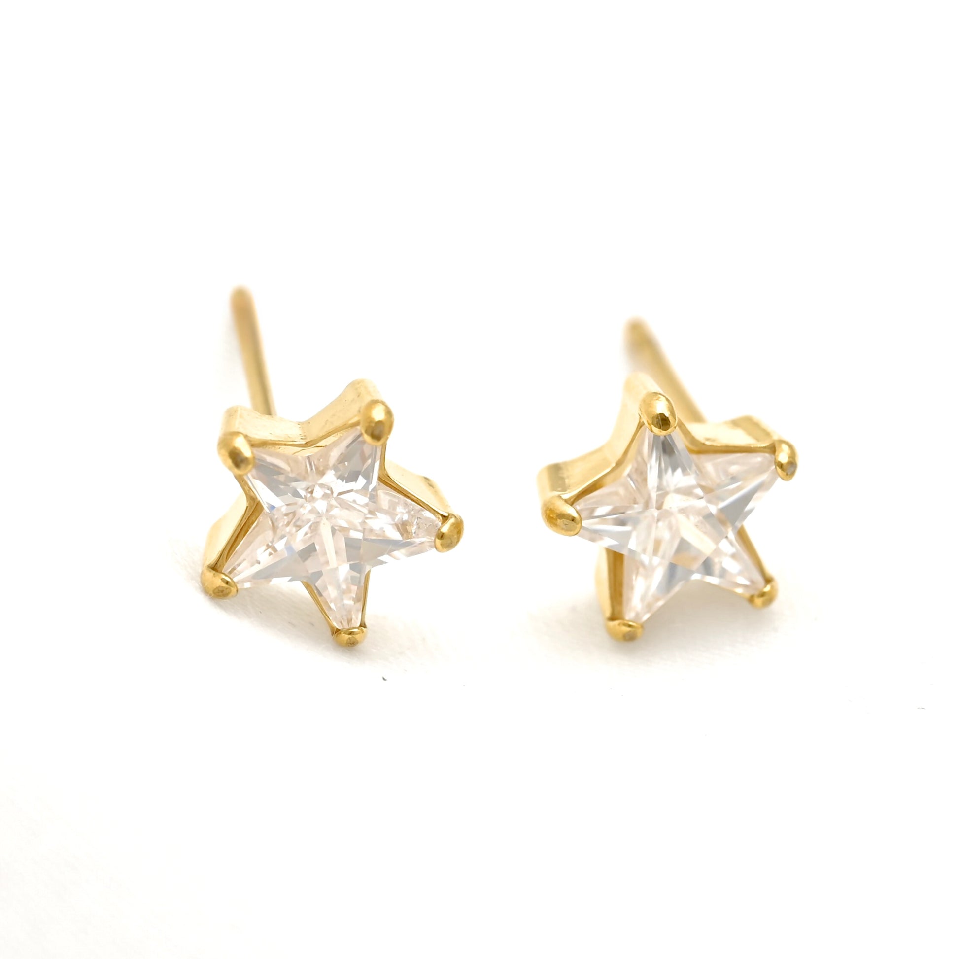 A pair of gold star-shaped stud earrings with clear, faceted star-cut CZ stones, displayed on a clean white background.