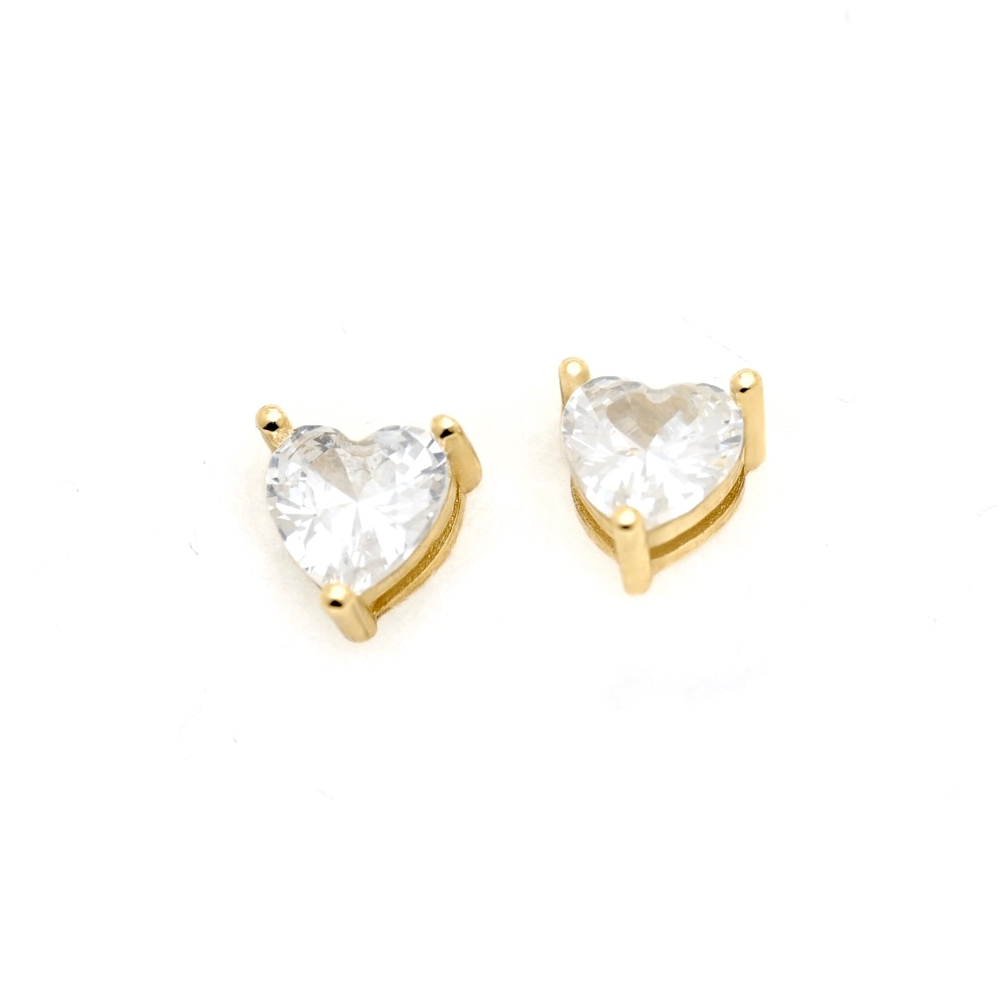A pair of heart-shaped stud earrings featuring clear heart-cut gemstones in gold prong settings, displayed on a clean white background.