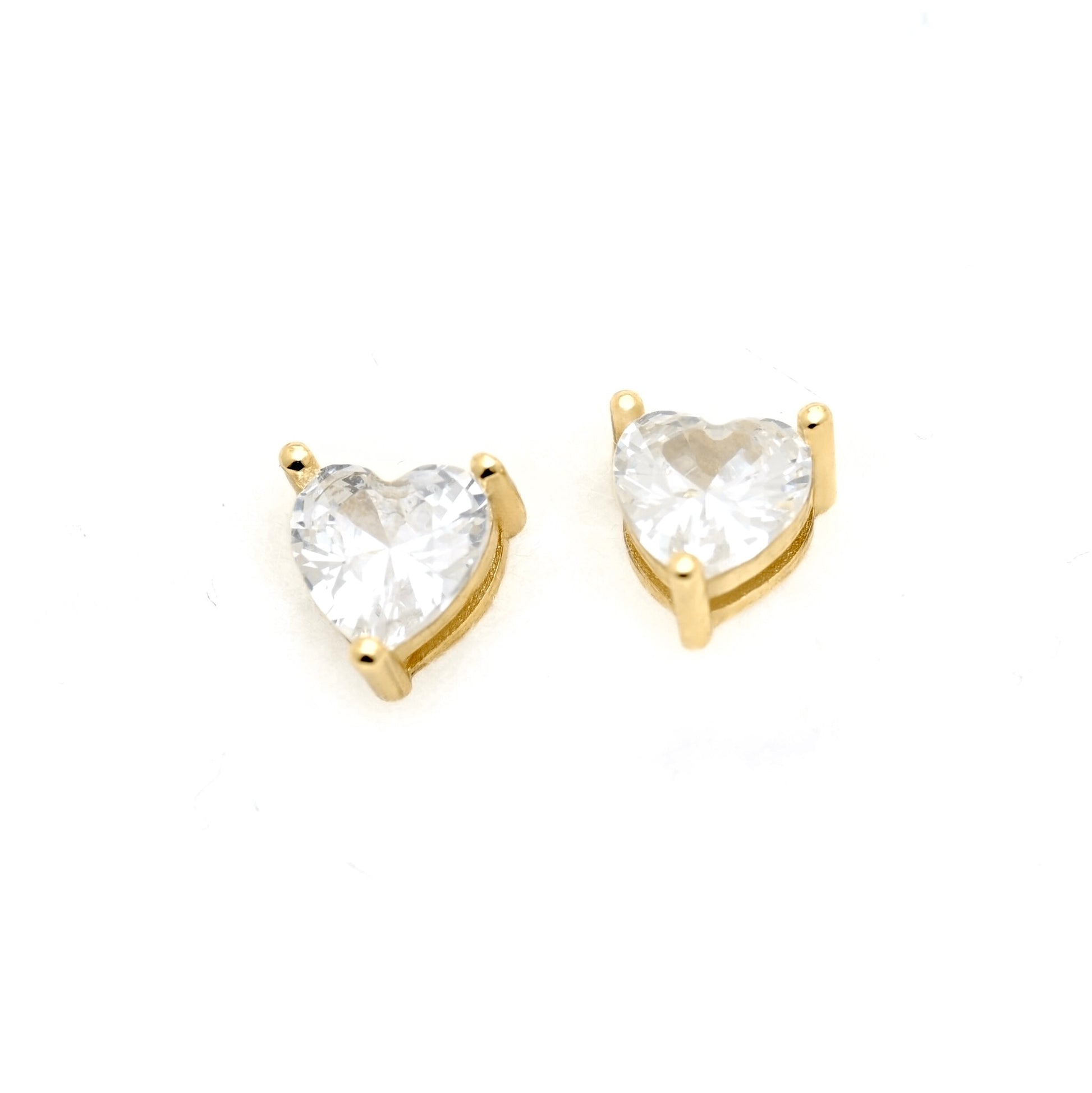 A pair of heart-shaped stud earrings featuring clear heart-cut gemstones in gold prong settings, displayed on a clean white background.