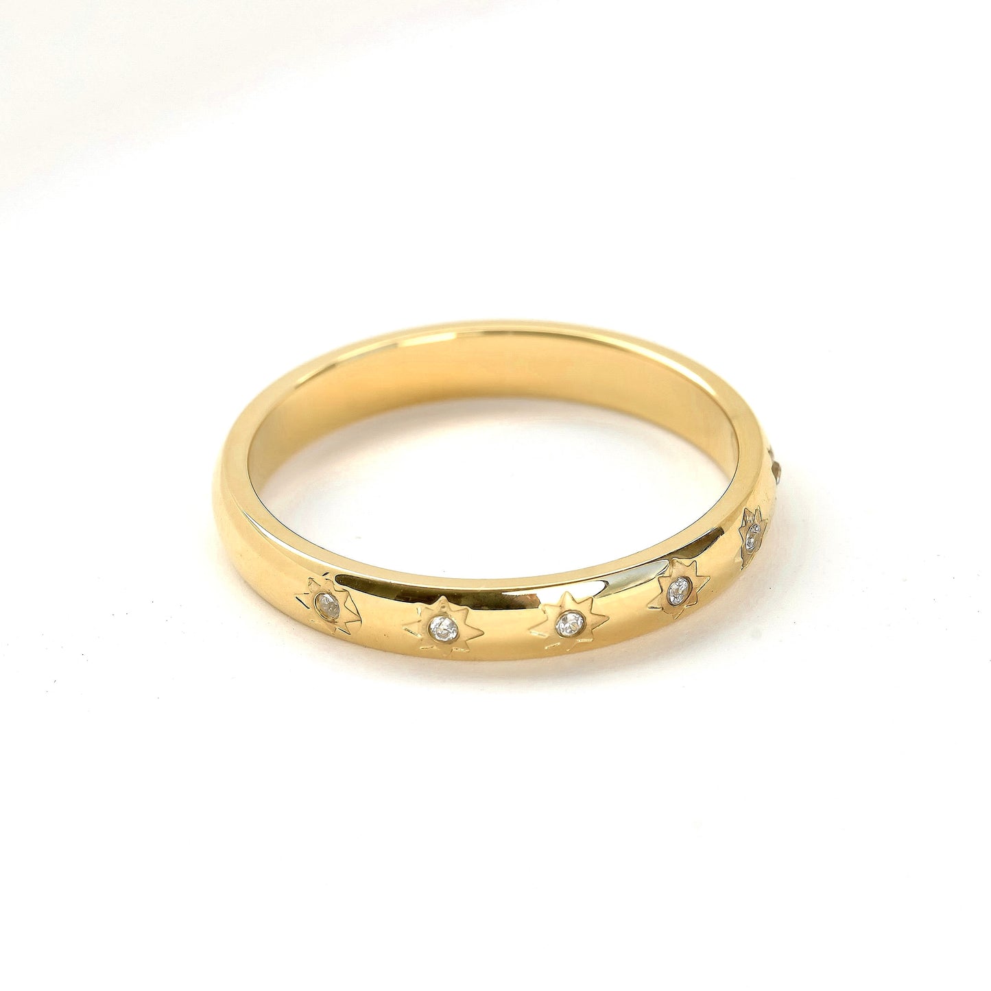 Top view of gold star-set ring with embedded cz stones on a white background