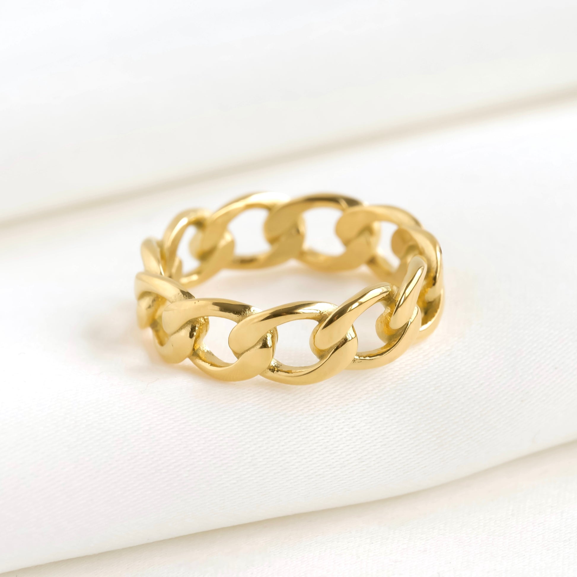 Gold chain-style ring on a white background