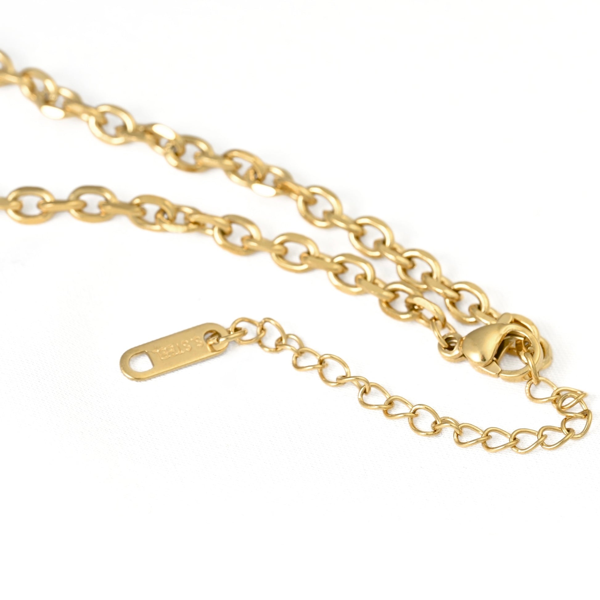 A close-up of a gold chain necklace with a lobster clasp and an adjustable extension link tag on a plain white background.