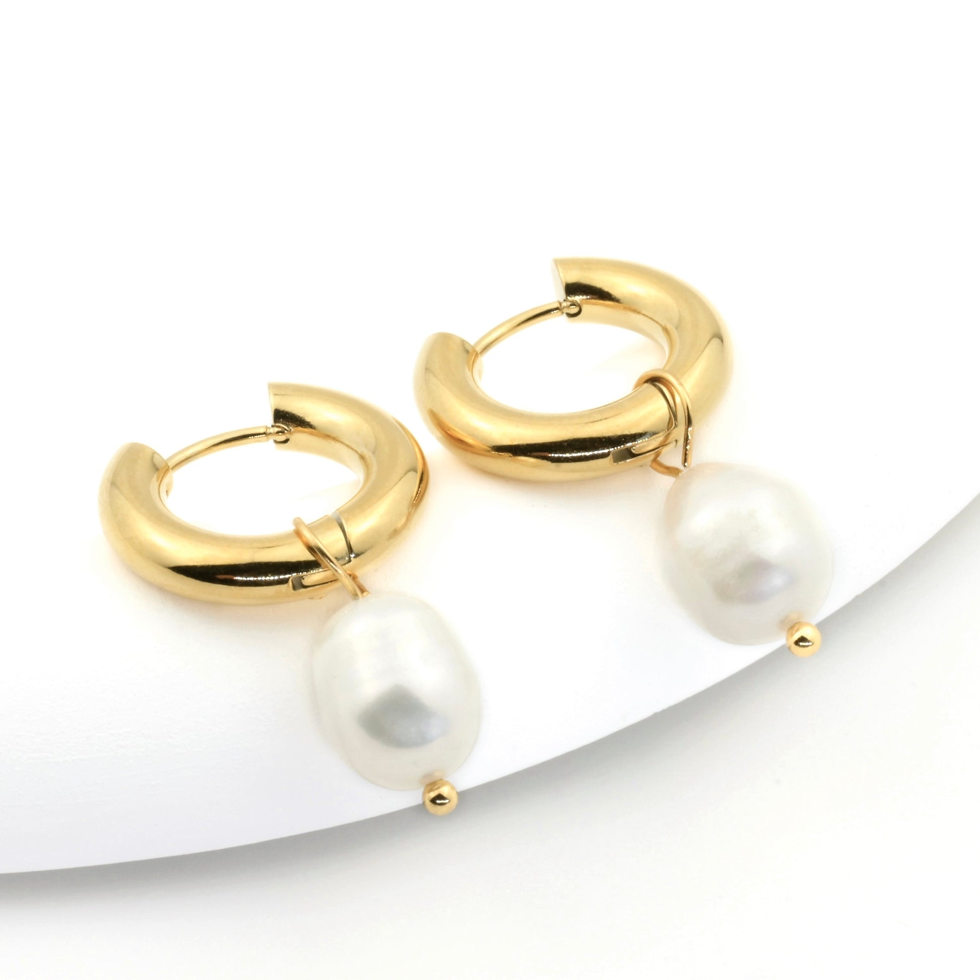 19mmchunky gold hoop earrings with pearl drops on a white background
