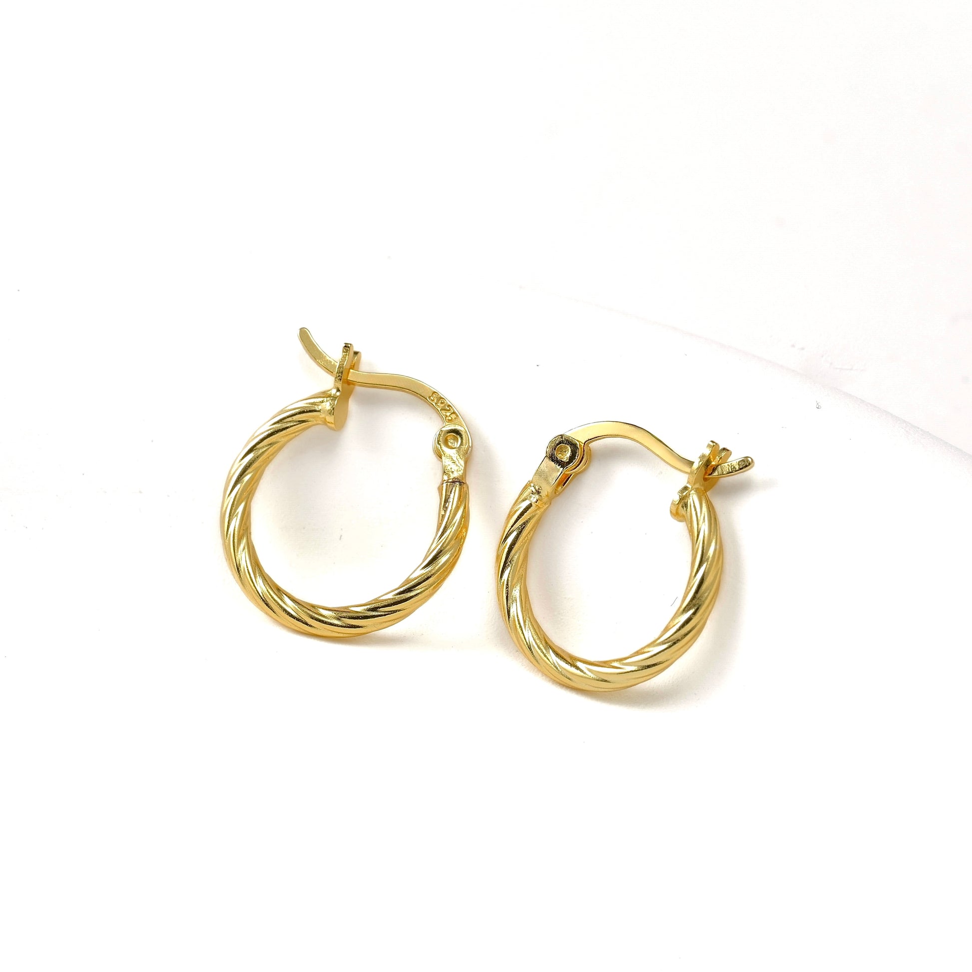 Mini gold hoop earrings  with S925 stamp on latch back  clasp on a white background