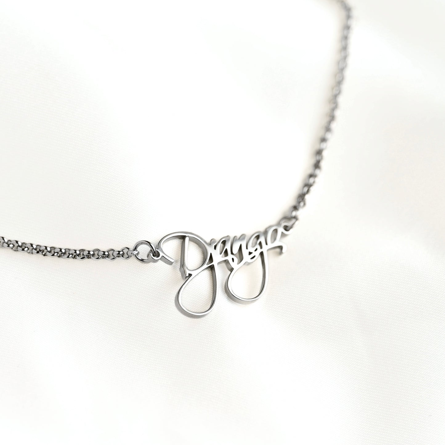 Silver necklace with name pendant on a white background