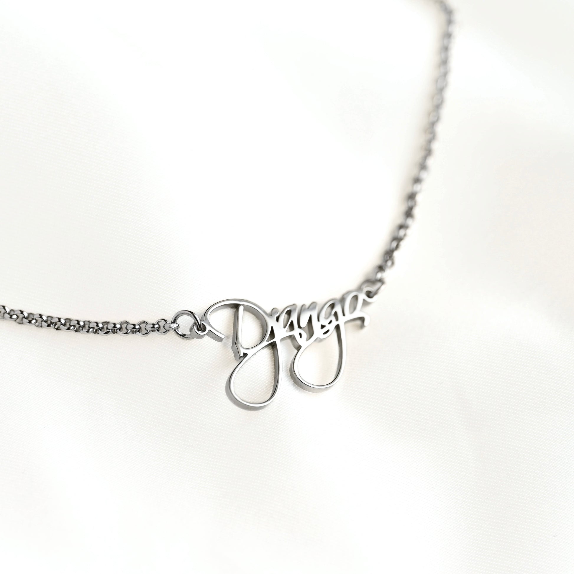 Silver necklace with name pendant on a white background