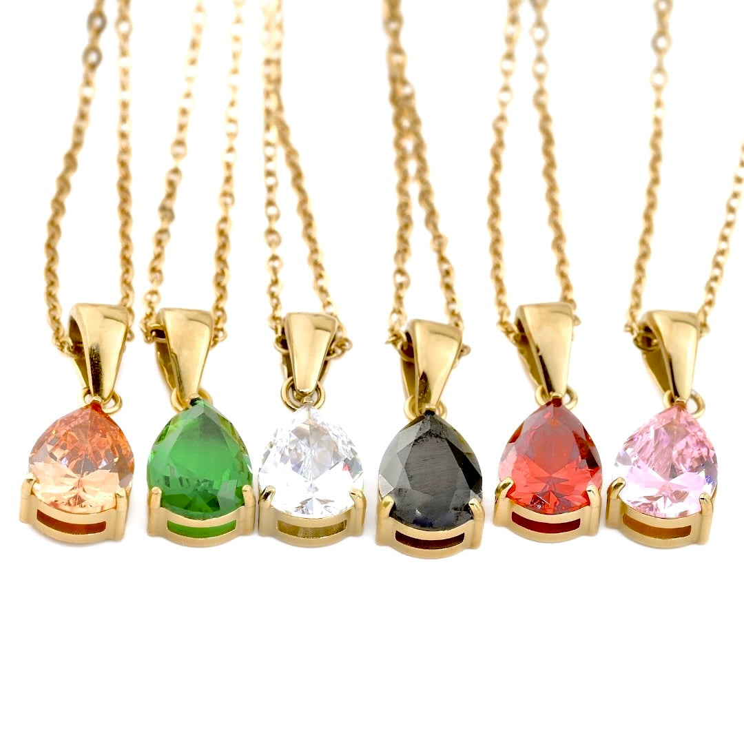 A set of gold necklaces with multiple pear-cut gemstones on a white surface
