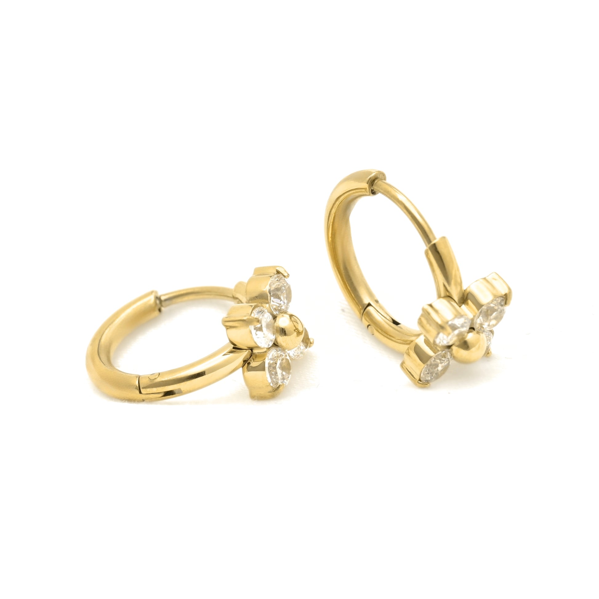 A pair of gold huggie hoop earrings with small flower-shaped crystal clusters, shown on a plain white background.