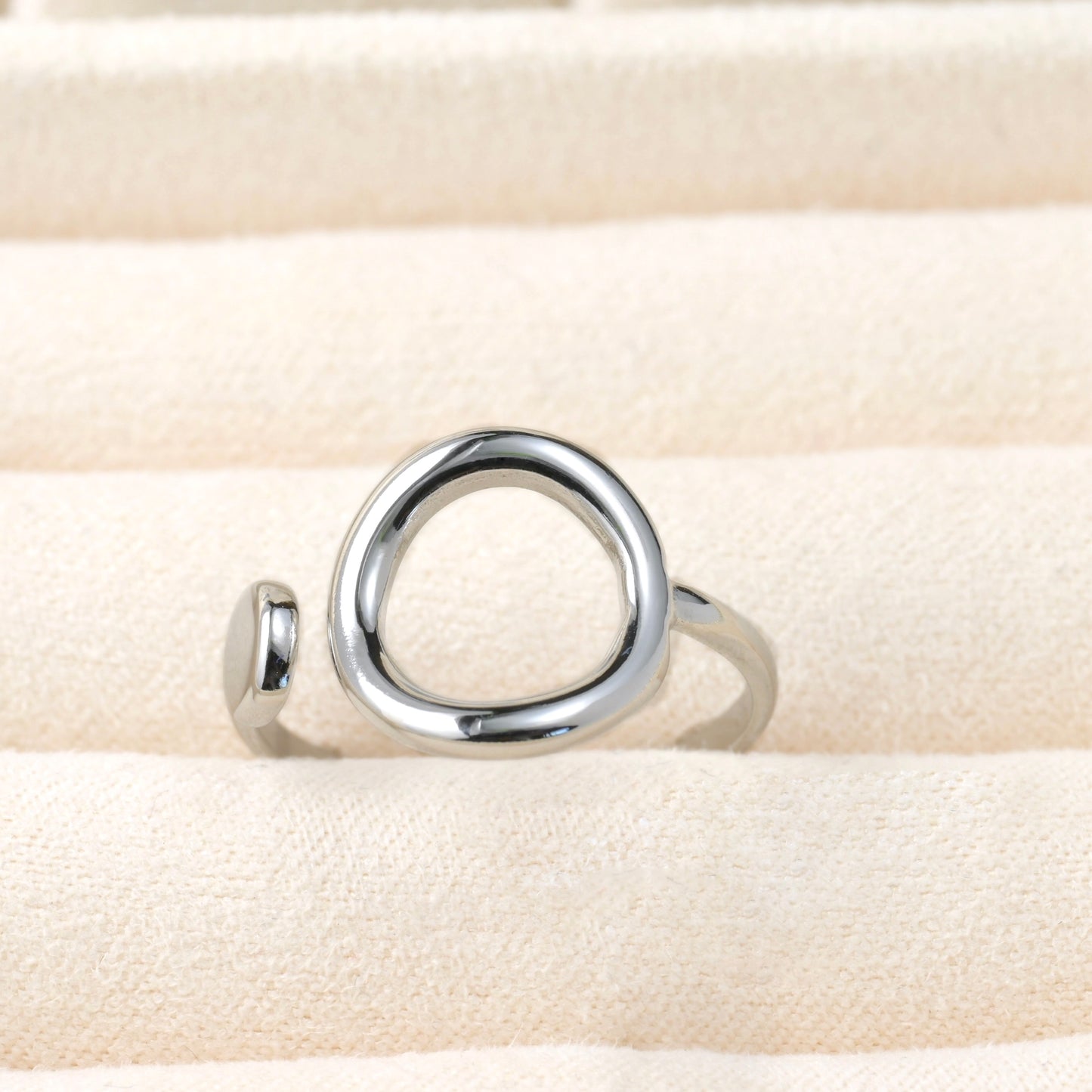 Silver ring on a beige fabric background
