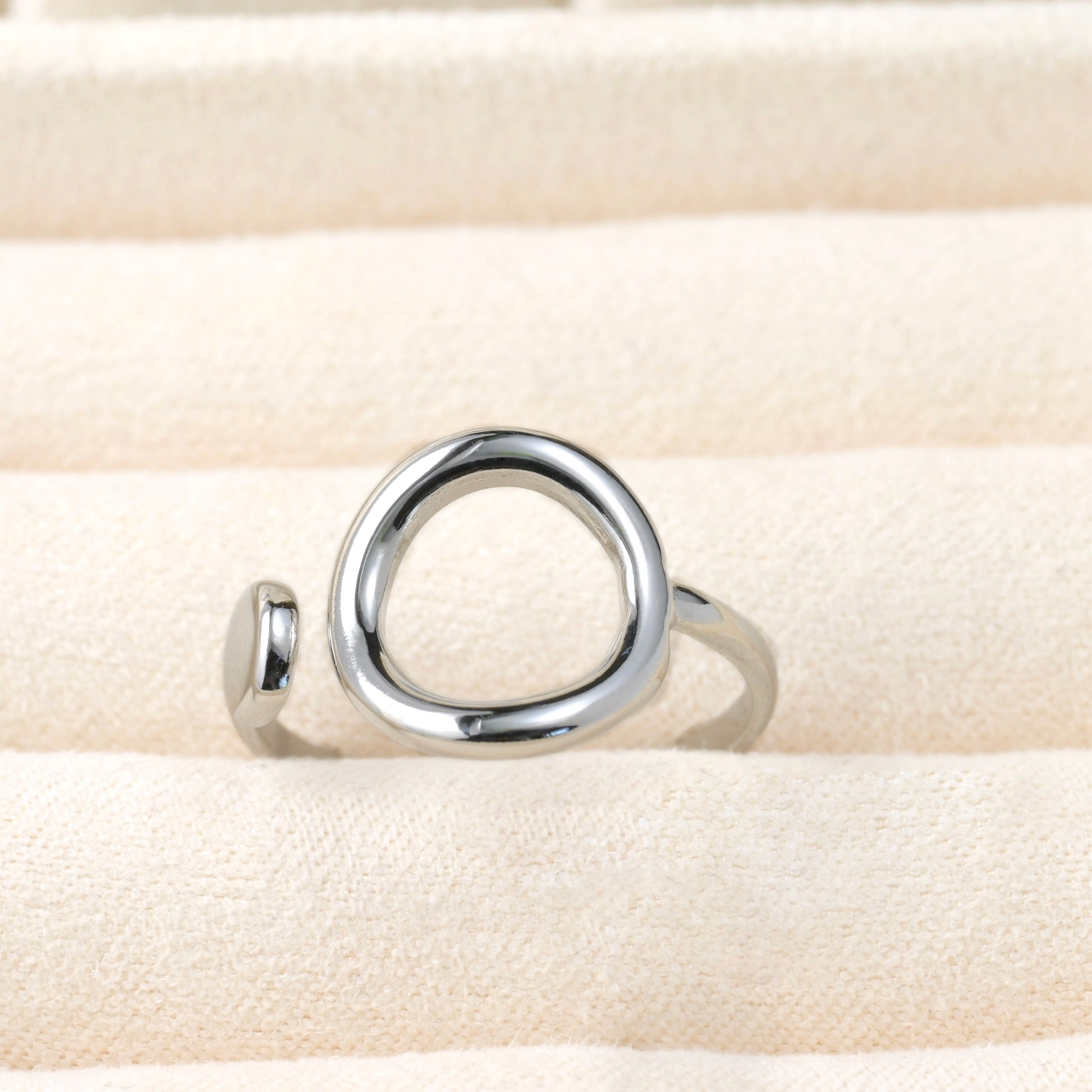 Silver ring on a beige fabric background