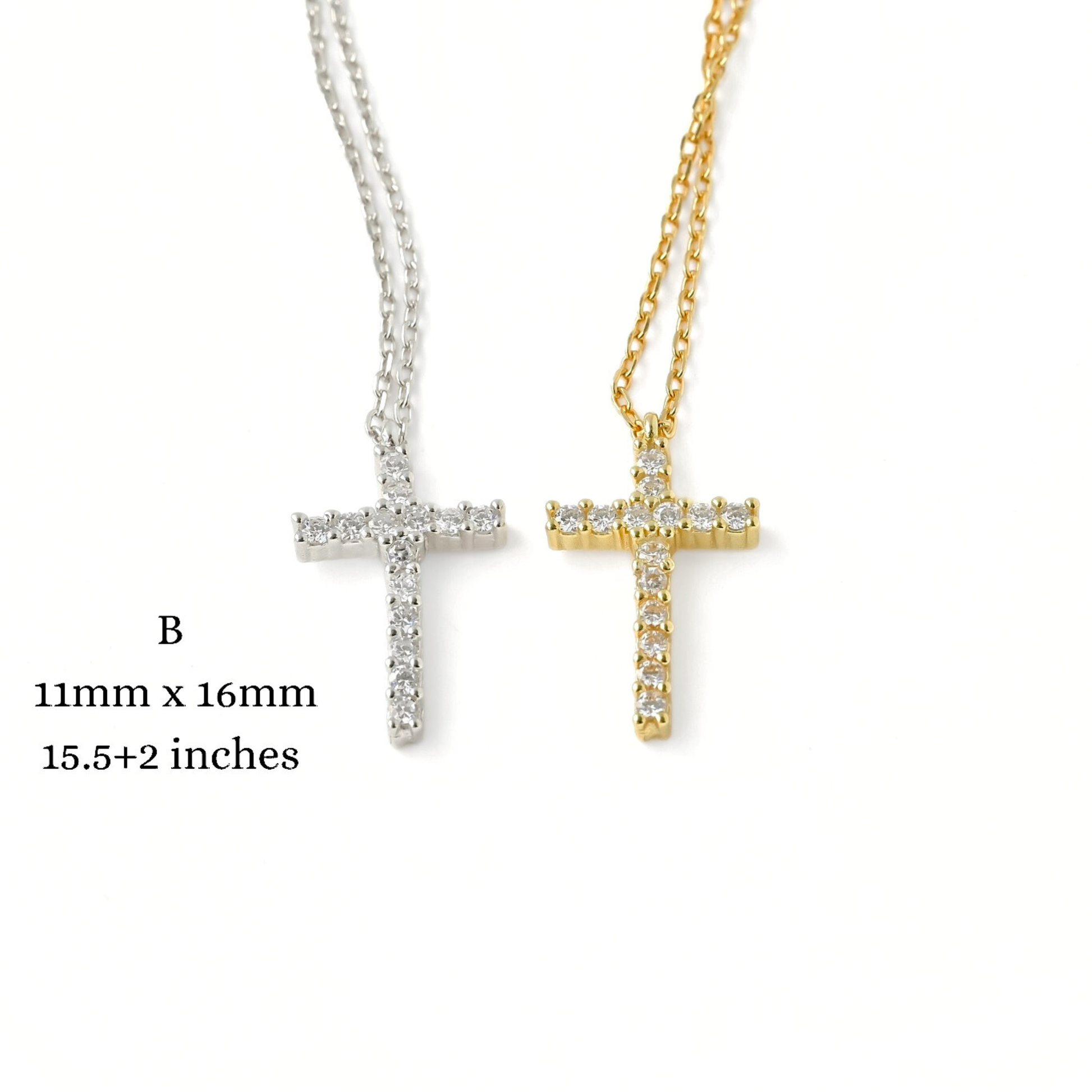 Two medium sized cross necklaces, one gold and one silver, with diamond accents on a white background with measurements.