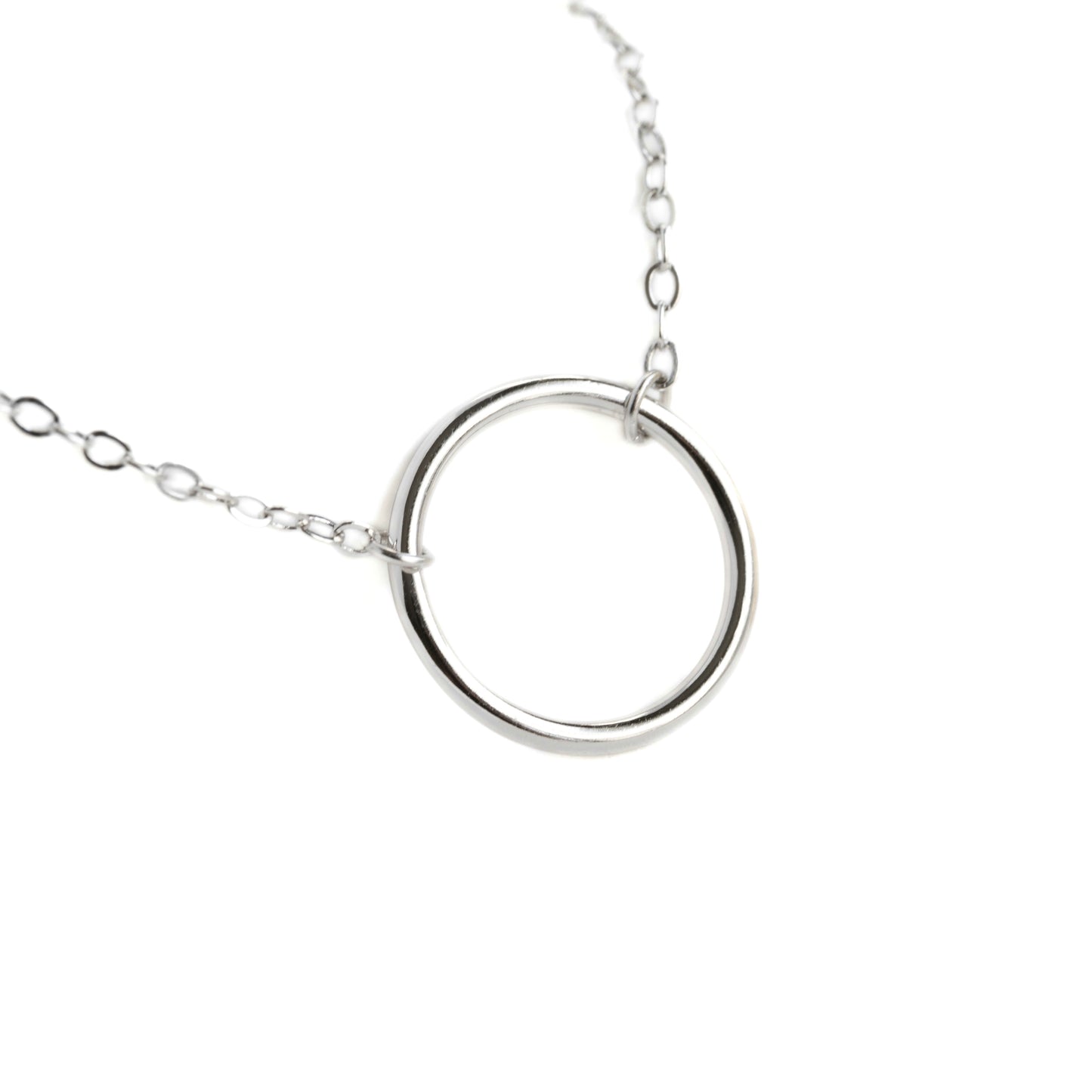 Silver necklace with an open circle charm  on a white background