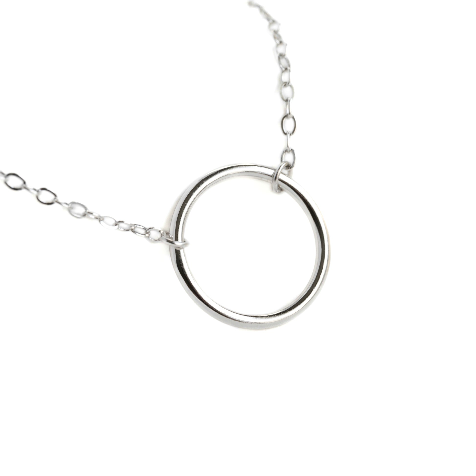 Silver necklace with an open circle charm  on a white background