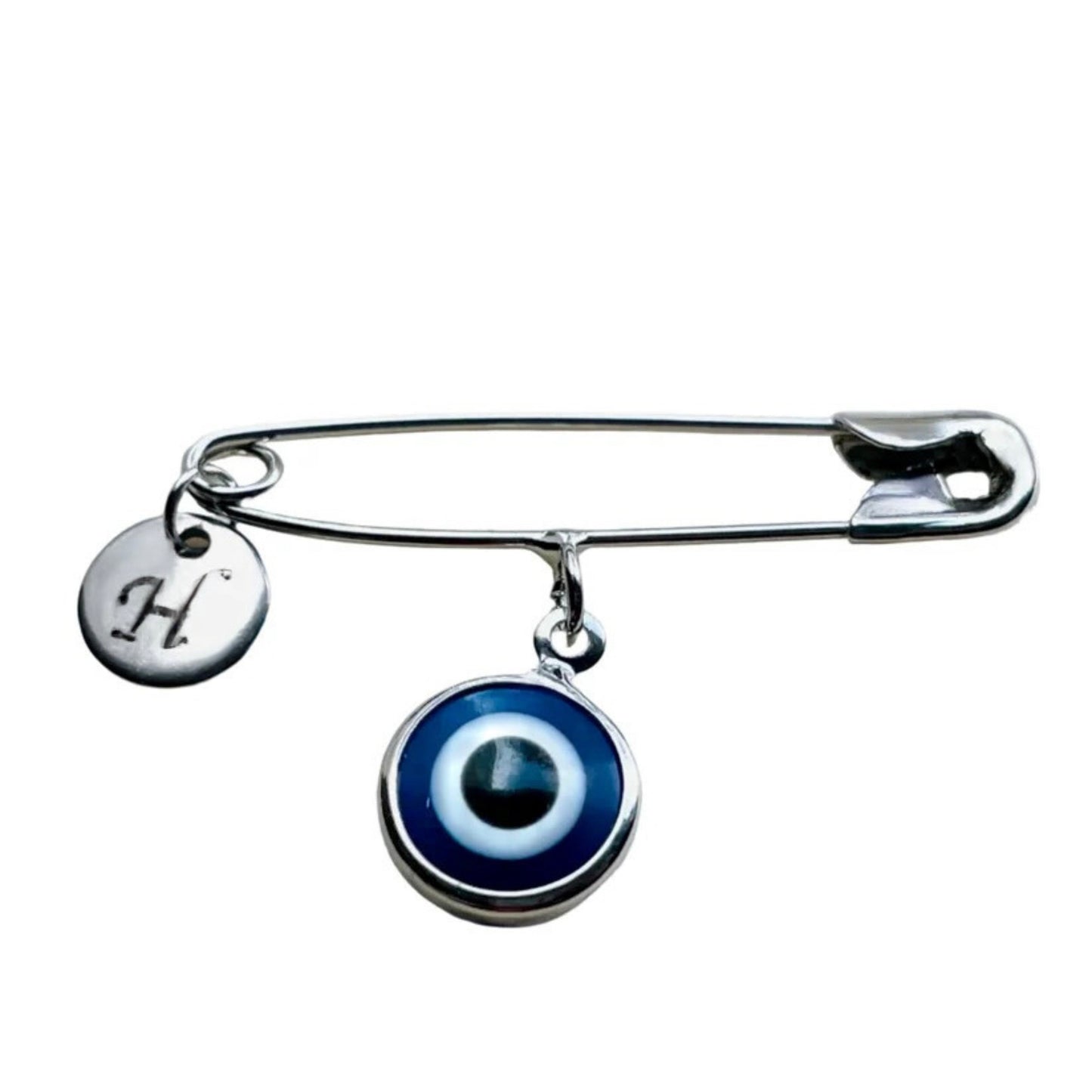 Silver brooch with an evil eye charm and a letter 'H' tag on a white background