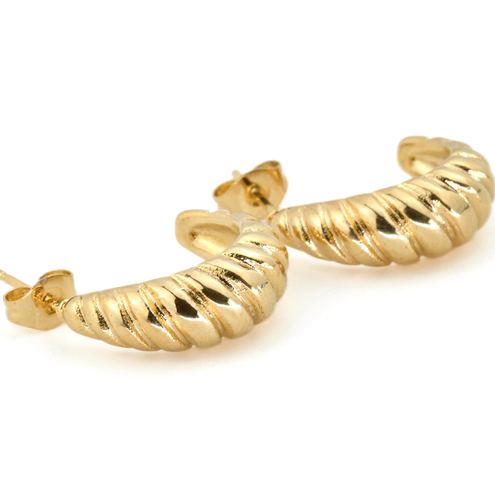 Close up view of gold hoop earrings on a white background