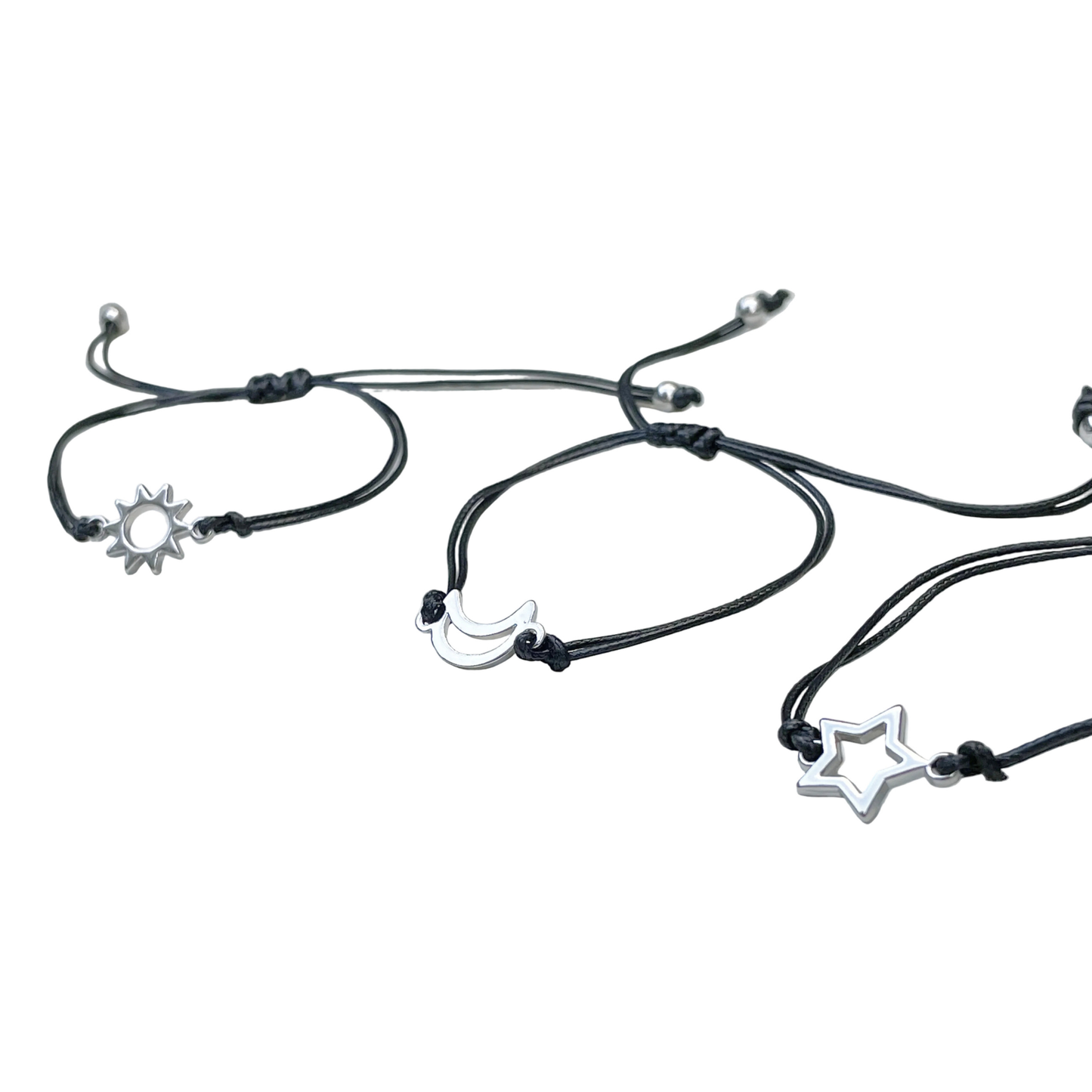 Black cord bracelets with star, moon, and sun charms on a white background