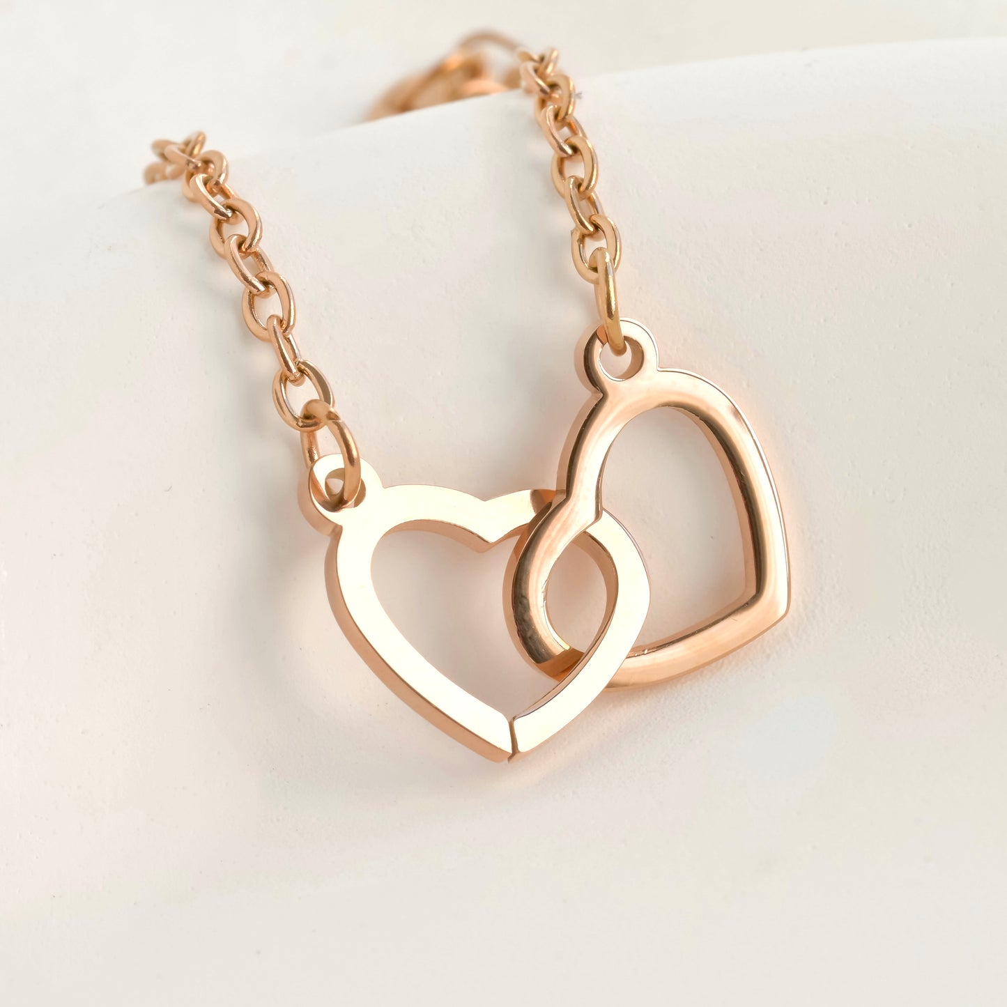 Rose gold double heart bracelet on a light background