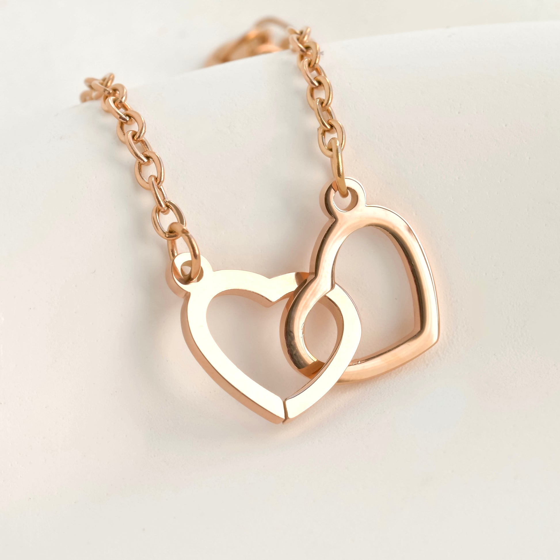 Rose gold double heart bracelet on a light background