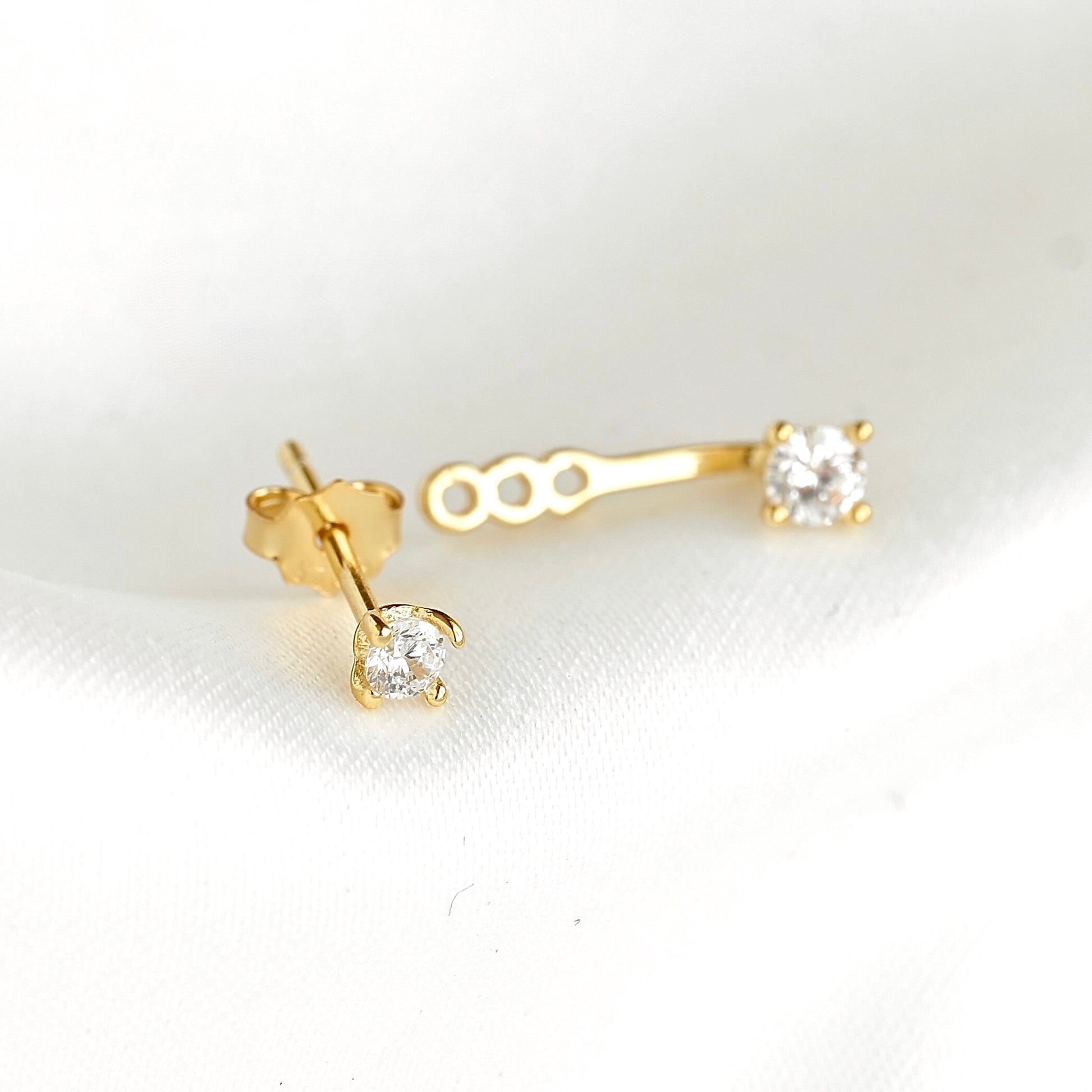 Gold ear jacket with a top stud with a tiny round cz stone and a backing with a tiny round cz stone and 3 slots displayed on a white background.