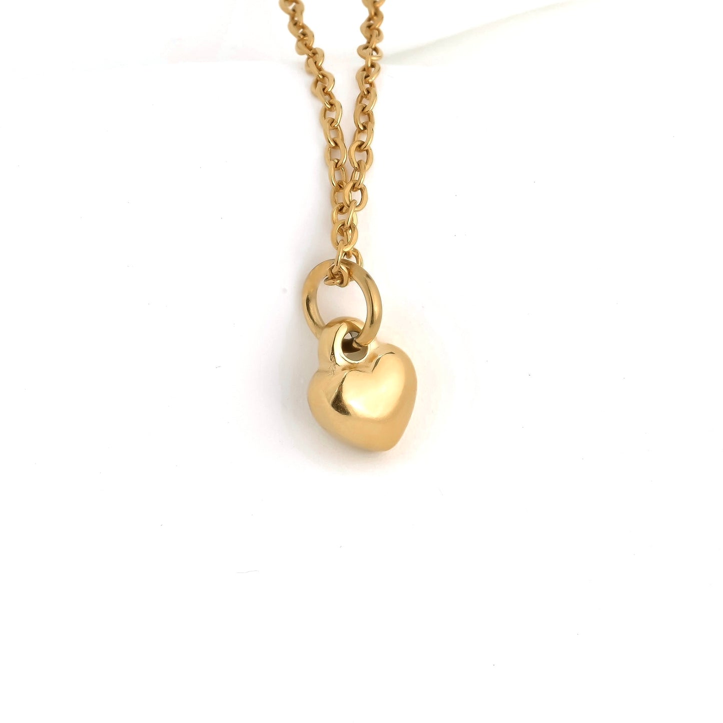 Gold tiny heart necklace on a white background
