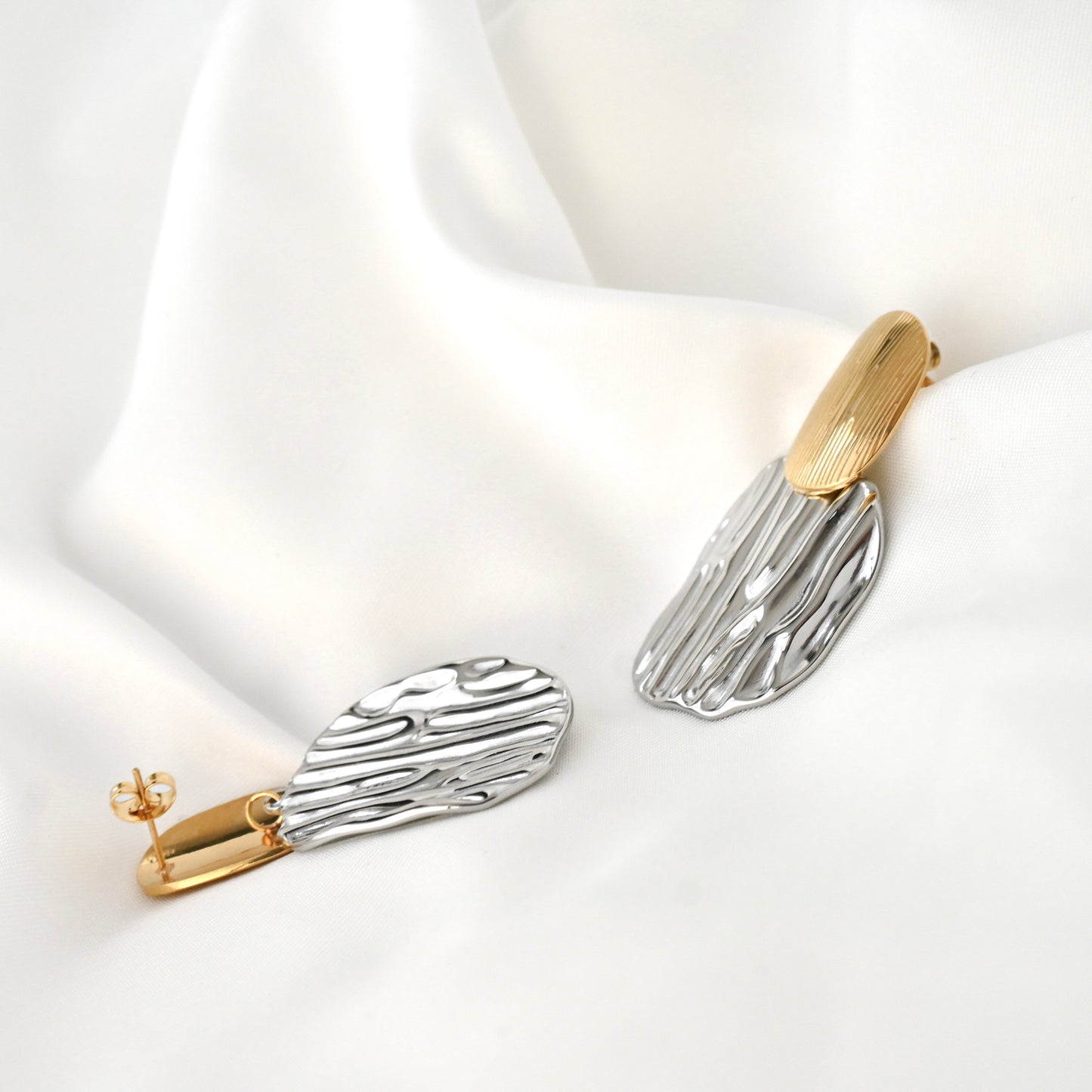 Pair of mixed metal earrings on a white background