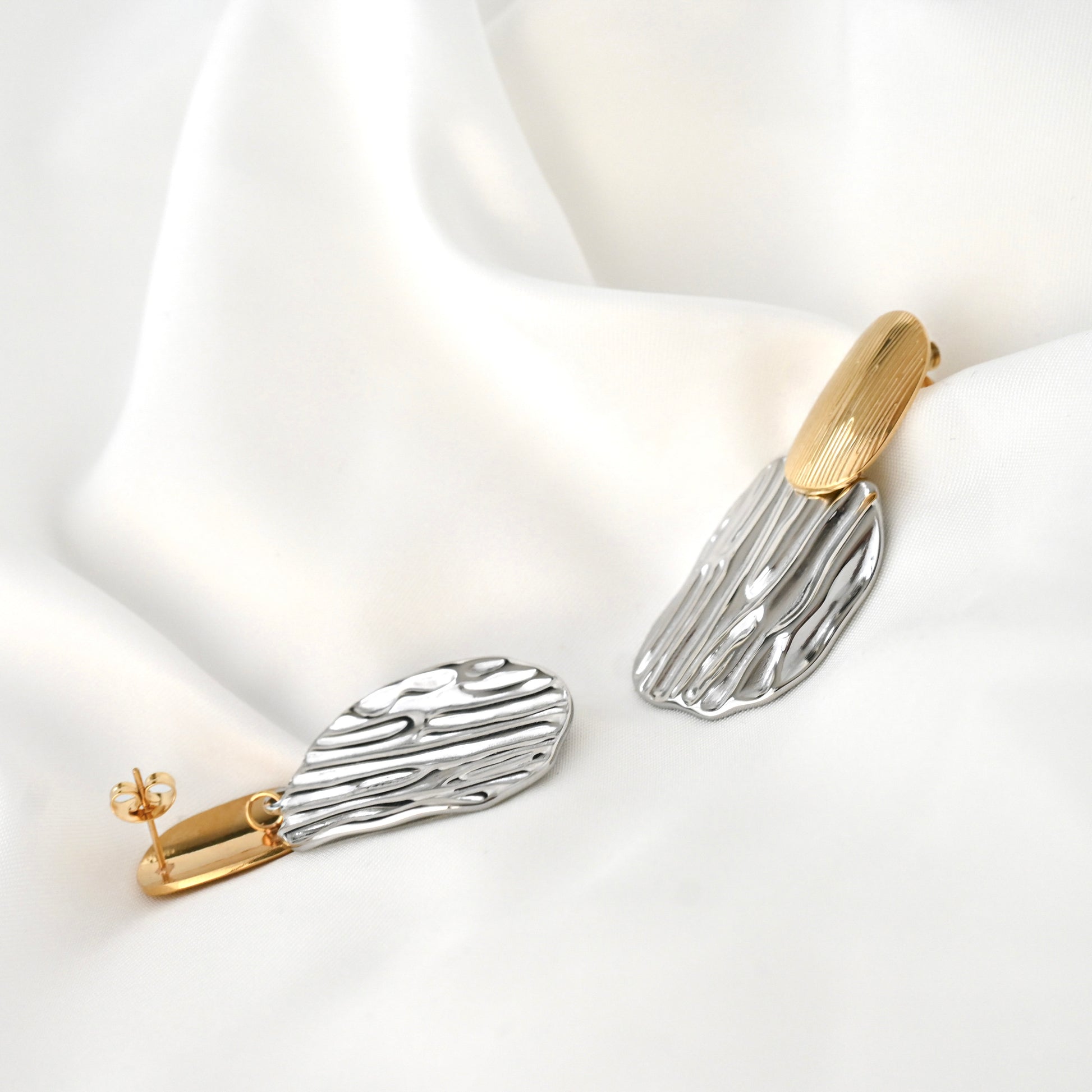 Pair of mixed metal earrings on a white background