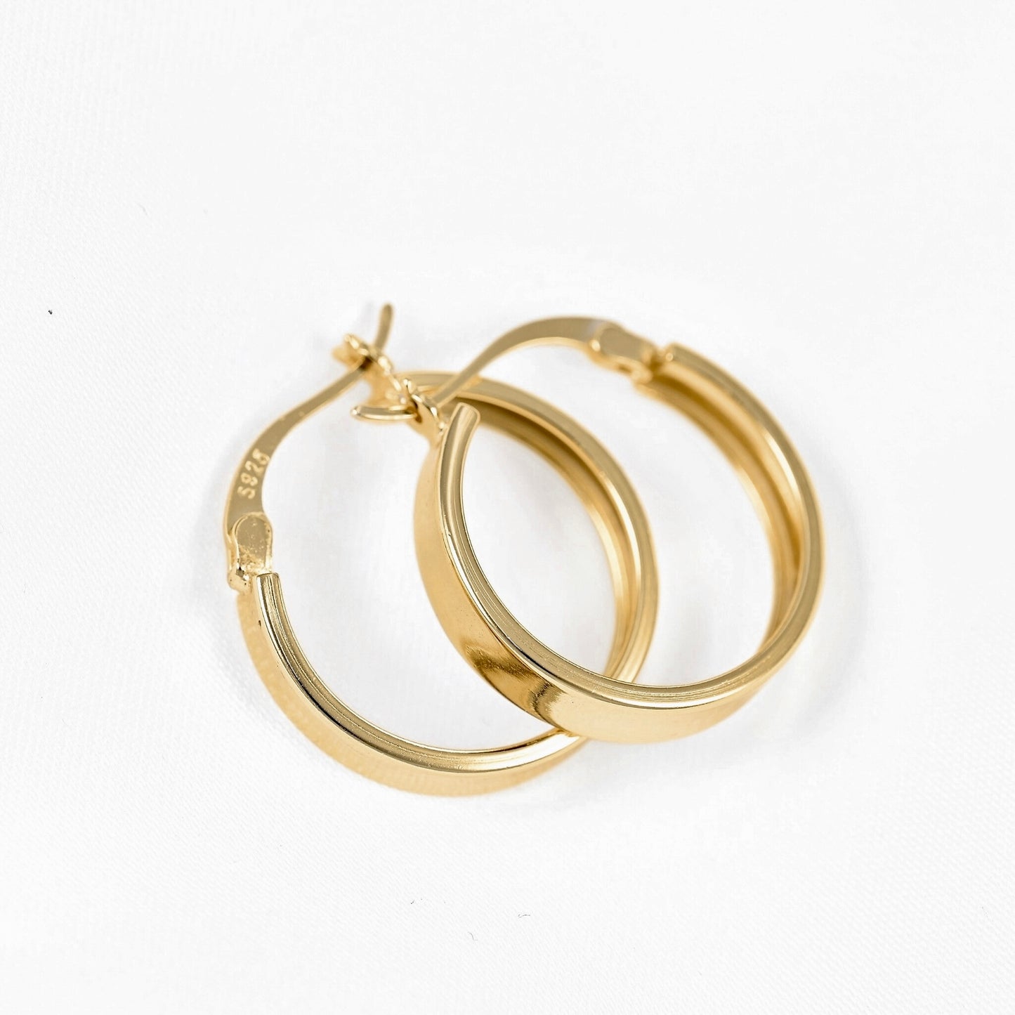A pair of polished yellow gold hoop earrings with a latch back clasp with S925 stamp, displayed on a clean white background.