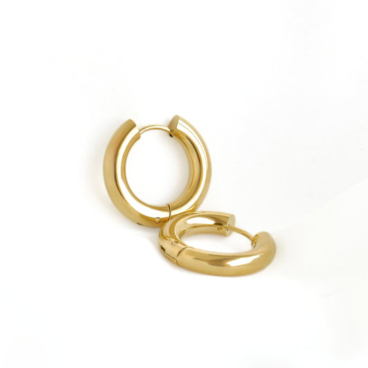 A pair of polished gold huggie hoop earrings on a clean white background.