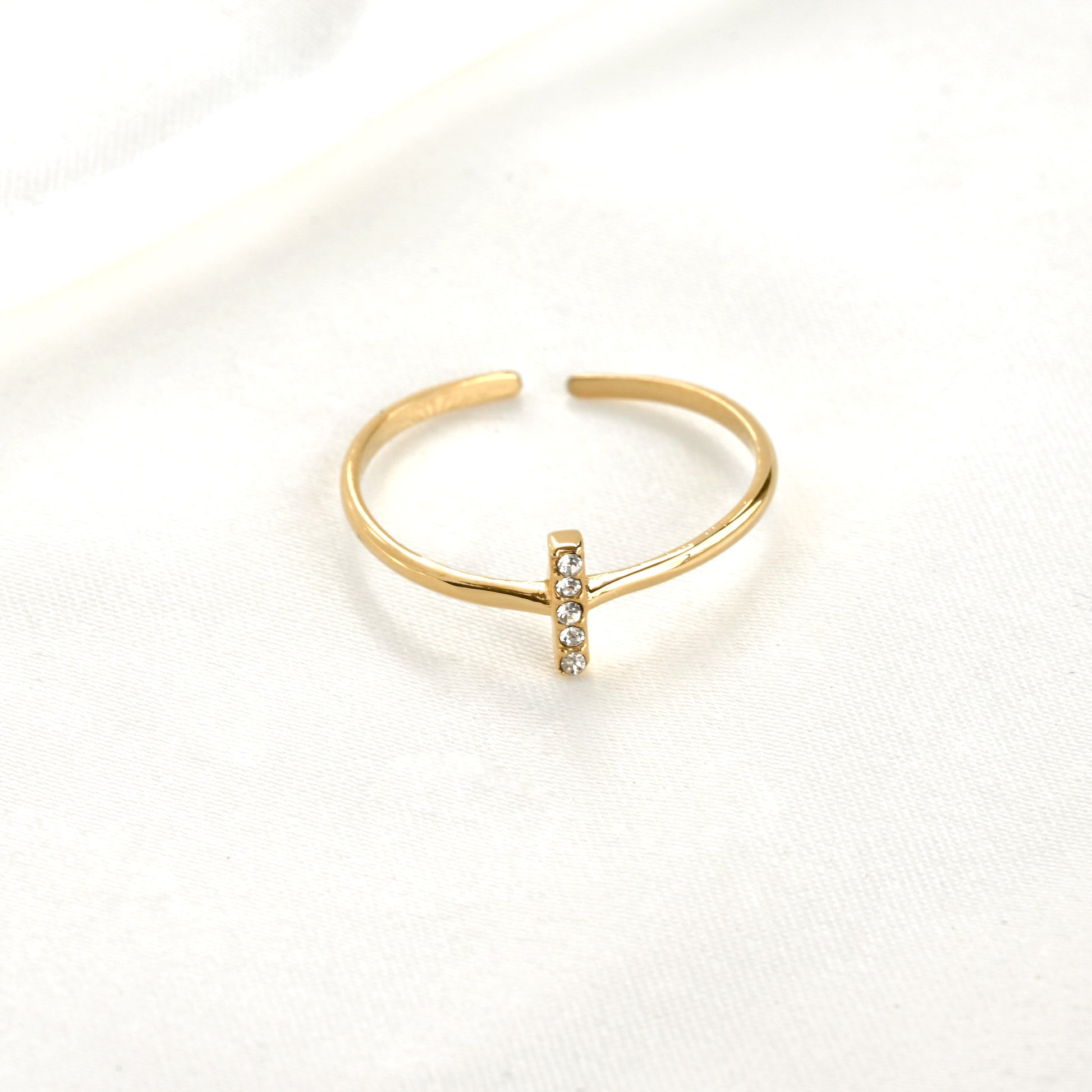 Front view of dainty  gold CZ ring with an open back design on a white background